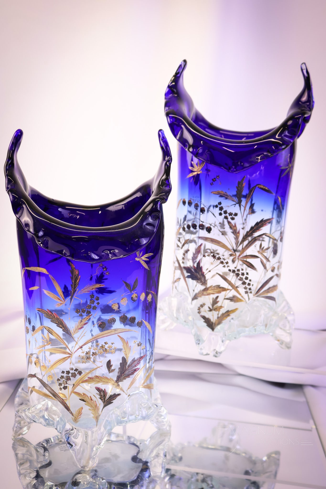 Pair Victorian Cobalt Clear Art Glass Bluerina Gilt Decorated Mantle Vases: A wonderful pair of Victorian cobalt to clear bluerina art glass mantle vases. Each is decorated with gold foliage and dragonflies. Each vase has applied glass feet. Both measures 10 1/2" tall. SHIPPI