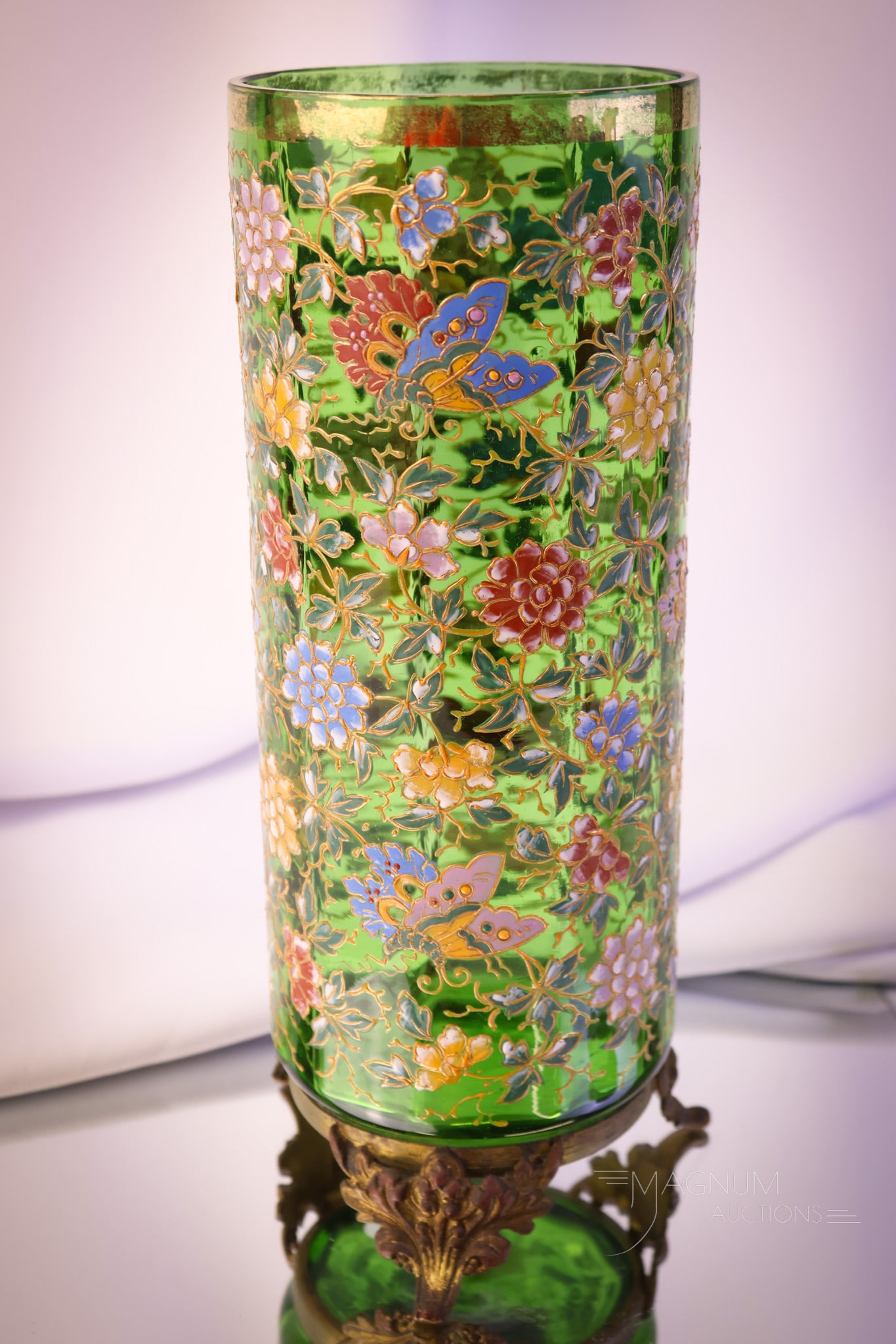 Moser Green Victorian Enameled Gilt Decorated Art Glass Vase: A nice find in an attributed to Moser art glass Victorian glass vase. This piece is green with enameled florals and butterflies with lots of gold. The vase has a metal ornate foot. The vase measures 1