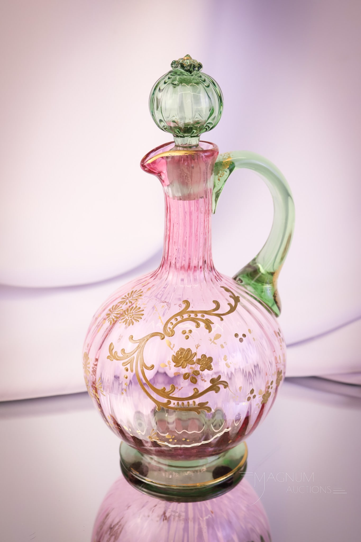 Rubina Verde Victorian Gilt Art Glass Claret Decanter: A beautiful find in a Victorian art glass claret decanter. This piece is in Rubina Verde. The claret has a green foot, handle, and stopper. The body is cranberry. The piece has delicate gold decoratio