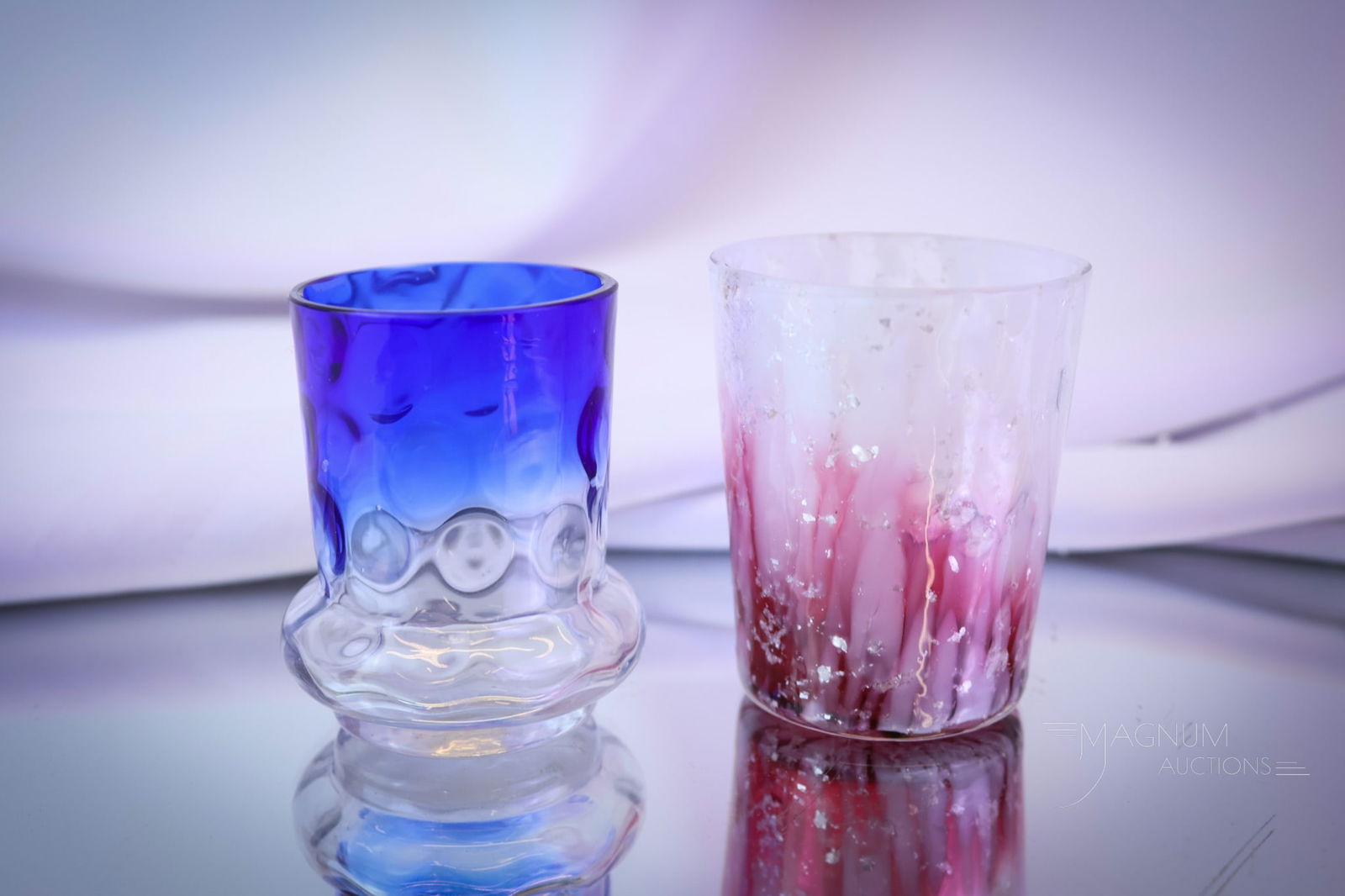 2 pc Lot Victorian Art Glass Toothpick Holders: Two nice examples of Victorian art glass toothpick holders. The first is a bluerina Bulge Base example. The second is a Phoenix Ruby to clear with white mica spatter. The tallest measures 2 1/4". SHIP