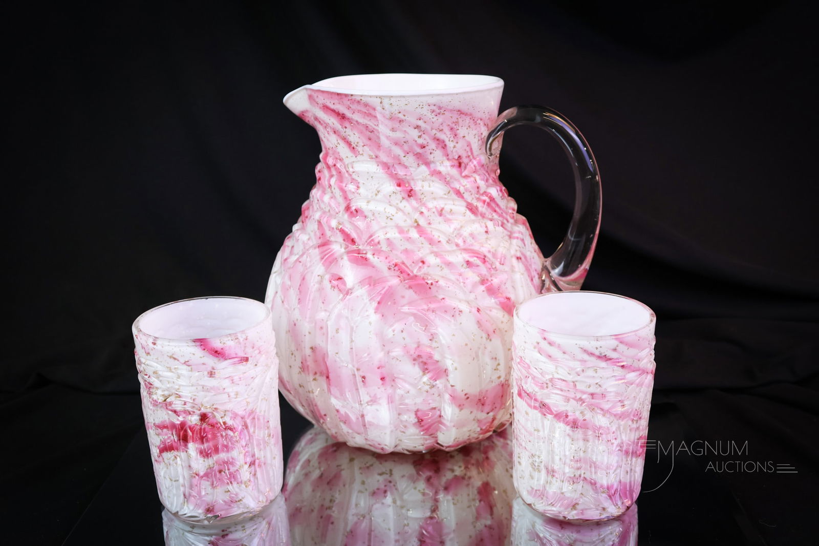 3 pc Set Northwood Leaf Mold Cranberry Mica Spatter Pitcher & Tumblers: A select offering of a Northwood Leaf Mold pattern water pitcher and two matching tumblers. These are in the cased cranberry mica spatter coloration. The tallest of the set measures 8". SHIPPING NOTIC