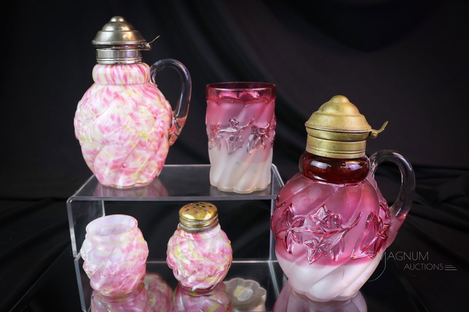 5 pc Lot Northwood Royal Ivy Victorian Glass: A combined lot of five pieces of the Northwood Royal Ivy pattern. This lot offers a syrup, a toothpick holder, and a salt shaker in the cased rainbow spatter coloration. There is also a syrup and a tu