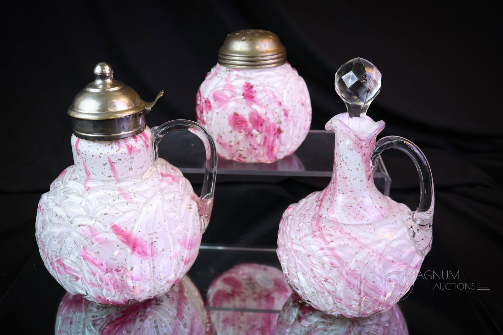 3 pc Lot Northwood Leaf Mold Cranberry Spatter Victorian Glass: Three selections make up this desirable lot of Northwood Leaf Mold pattern. This lot includes a syrup, a cruet, and a sugar shaker. The tallest measures 61/4". SHIPPING NOTICE: If you choose not to ut