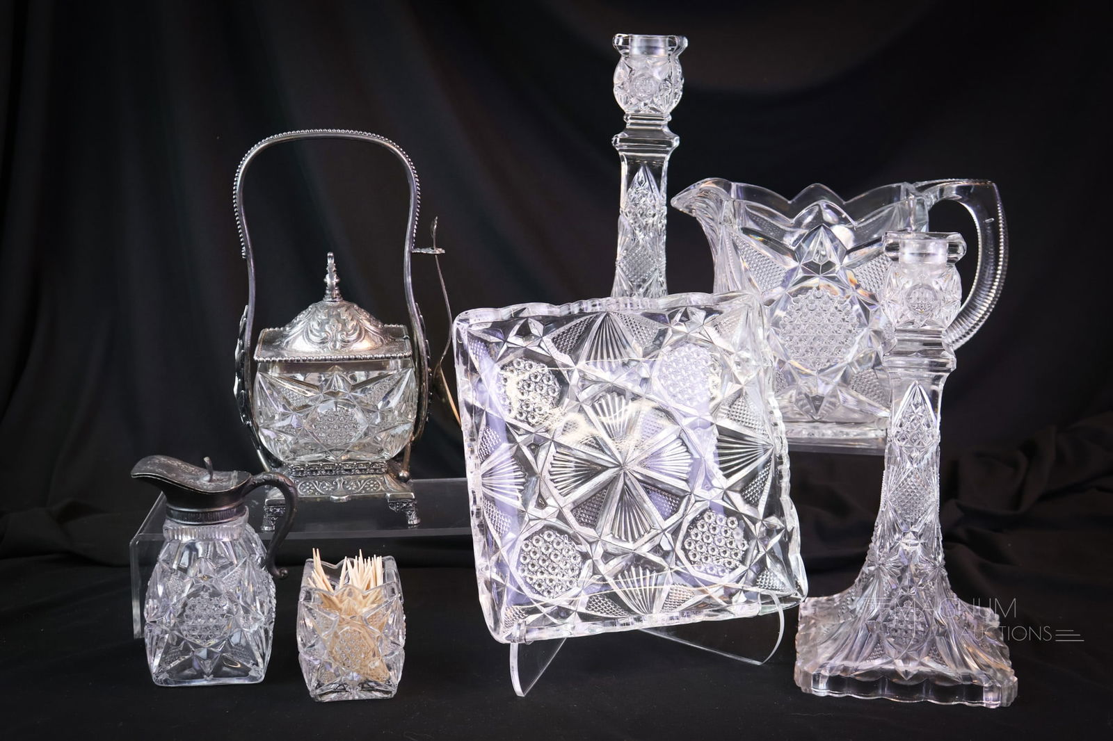 7 pc Lot U.S. Glass Illinois Victorian Glass Candlesticks Pitcher & More: A generous offering of seven pieces of U.S. Glass Illinois pattern. This lot includes a water pitcher. A pair of candlesticks. A syrup and toothpick holder. Lastly, there is a meriden silverplate pick