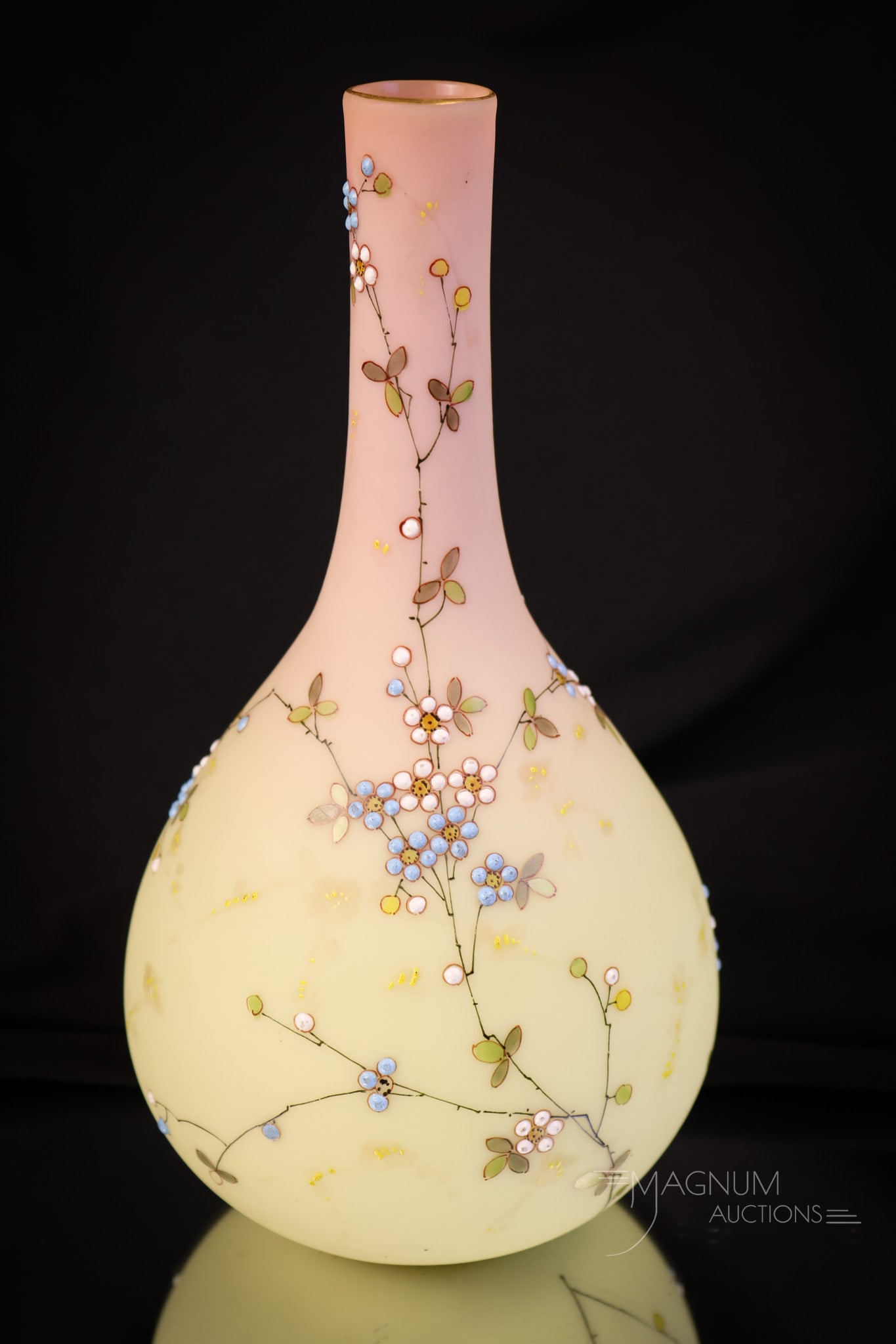 Mt. Washington Burmese Enamel Gilt Decorated Glass Vase: Take note of the fine decoration on this piece of Mt. Washington Victorian decorated burmese glass. This bottle-shaped vase measures 8" tall and 4" wide. It has an all-over floral decoration of