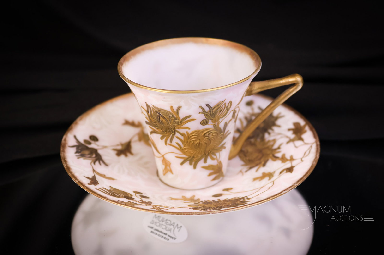 Signed Mt. Washington Crown Milano Demitasse Victorian Cup & Saucer: A wonderful offering of a signed Mt. Washington Crown Milano demitasse cup and saucer. It has a gorgeous decoration of a pink background design with florals and gold. The piece measures 2 3/4" tall an