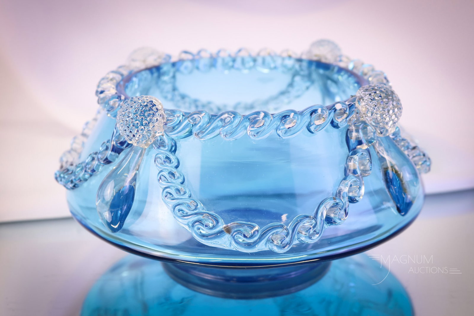 Peacock Blue Victorian Applied Glass Vase: A striking peacock blue Victorian applied glass vase. This piece features clear applied glass swags, tendrils, and prunts. The vase measures 4" tall and 7 3/4" wide. SHIPPING NOTICE: If you choose not