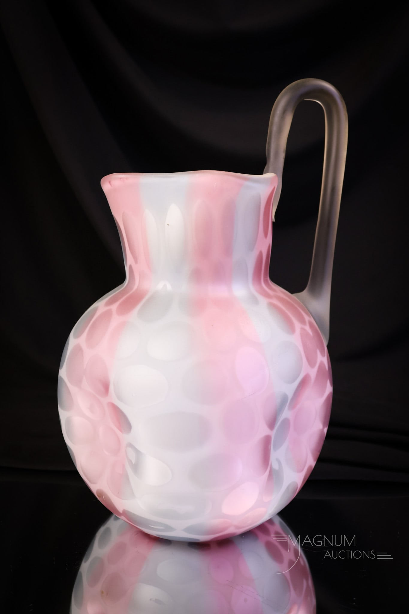 Phoenix Harrach Victorian Rainbow Mother of Pearl Satin Glass High Handle water Pitcher: A beautiful find in a Victorian water pitcher. This one is in rainbow mother-of-pearl satin glass. The pitcher features colors of pink and blue. It also has a high-pulled-up handle and in a coinspot p