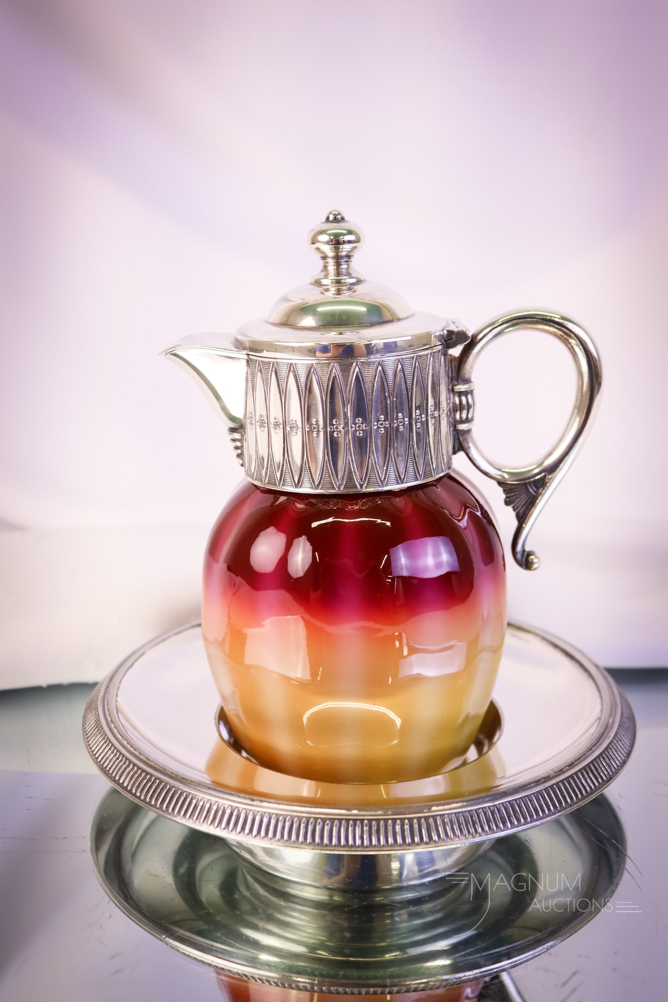 New England Plated Amberina James Tufts Silverplate Victorian Syrup Pitcher: A gorgeous find in a Victorian Plated Amberina glass syrup pitcher, complete with its original James Tufts silverplate underplate. This excellent example measures 5 1/2" tall and 5 3/4" wide. SHIPPING