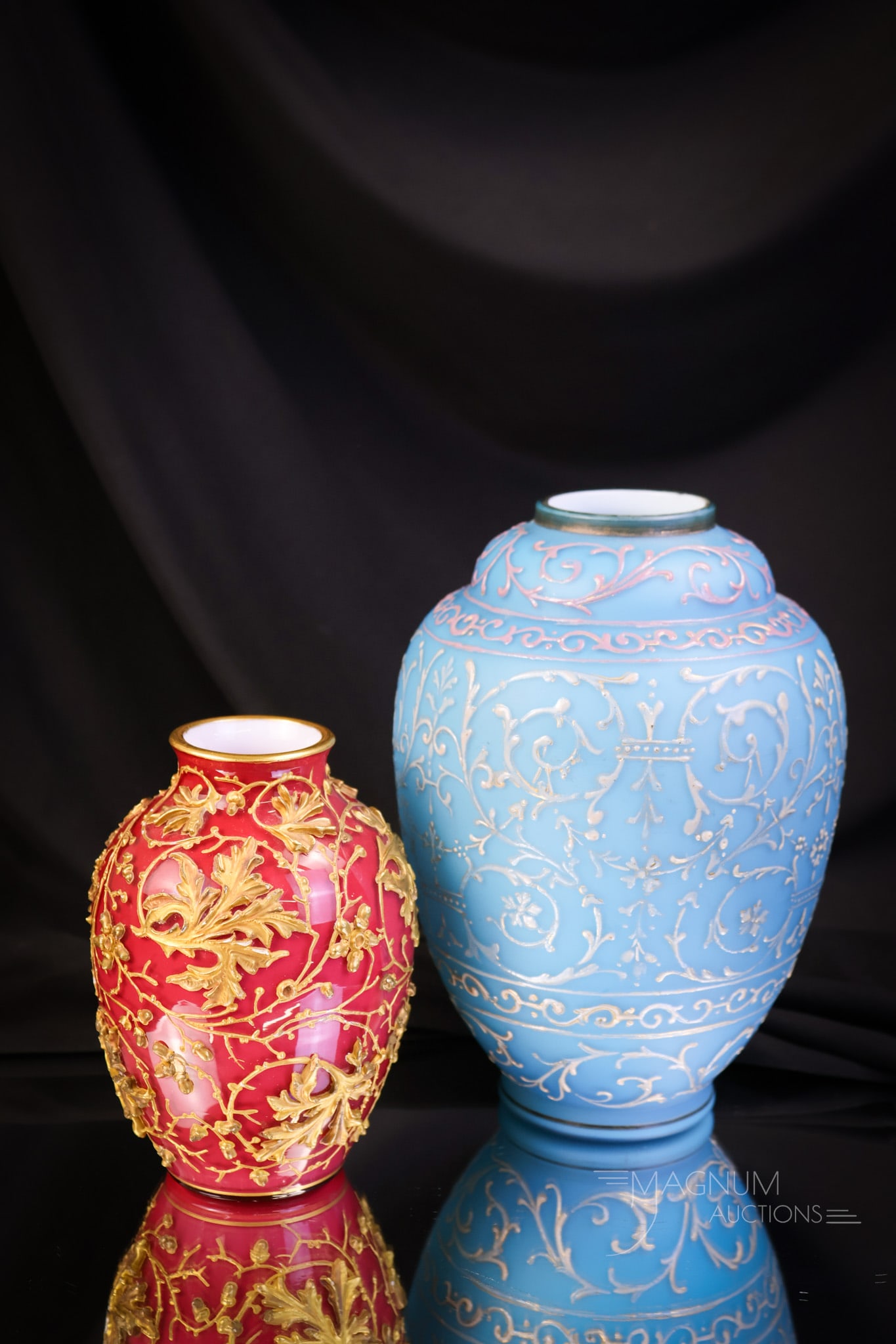 2 pc Lot Victorian Enameled Gilt Art Glass Vases: Two desirable finds in Victorian art glass. These two vases will complement any collection. The first is a pink-cased example with built-up enamel work decoration. The second is a blue satin example w