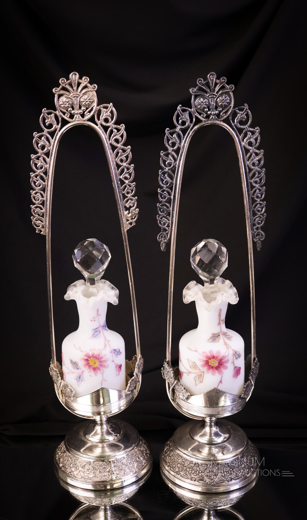 Pair Rogers Victorian Silverplate Enameled Satin Glass Perfume Bottle Castors: A beautiful pair of decorated Victorian satin enameled glass perfume bottles set in matching Rogers silverplate holders. Each of these perfume castors features an ornate holder with a decorated perfum