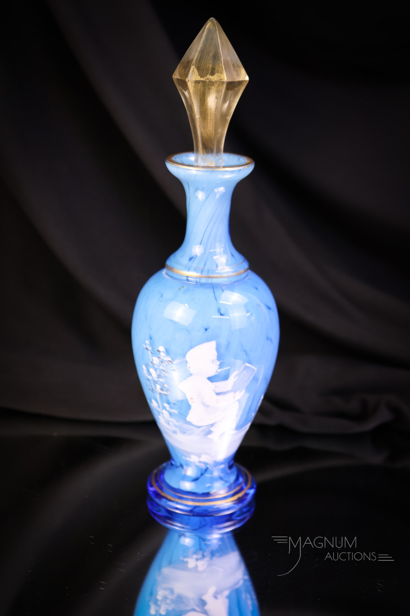 Victorian Cased Spatter Glass Mary Gregory Perfume Bottle: A fine, blue spatter, cased glass perfume bottle. This bottle has a decoration of a Mary Gregory figure. The stopper is gilt decorated. The perfume measures 7" tall and 2" wide. SHIPPING NOTICE: If yo
