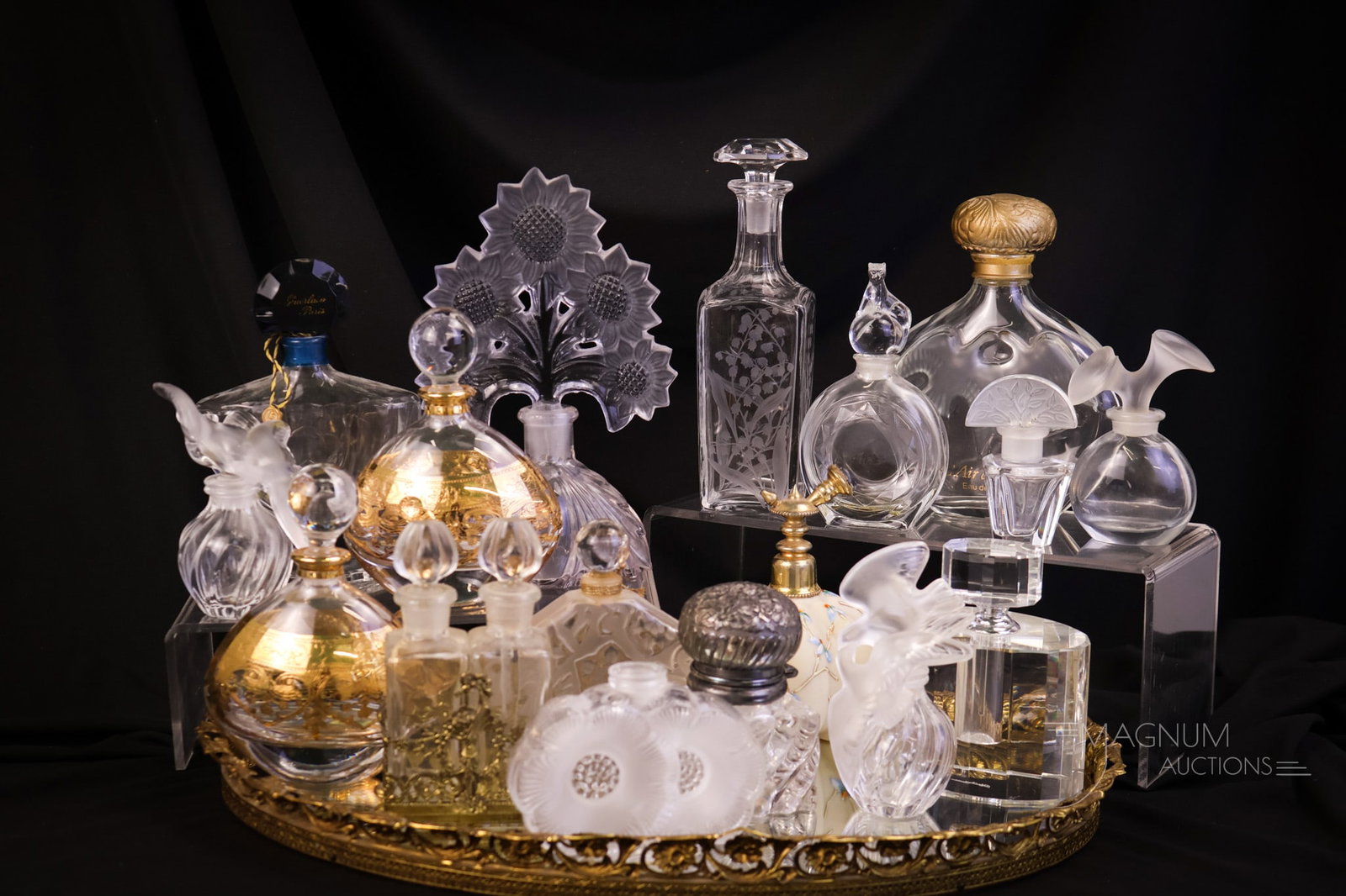 19 pc Lot Mirrored Tray Perfume Bottle Collection Baccarat Cartier Lalique & More: Straight off the consignor's dresser. This is an instant perfume bottle collection. The 19-piece lot includes a filigree mirrored dresser tray. Makers of the perfume bottles include Lalique, Baccarat,