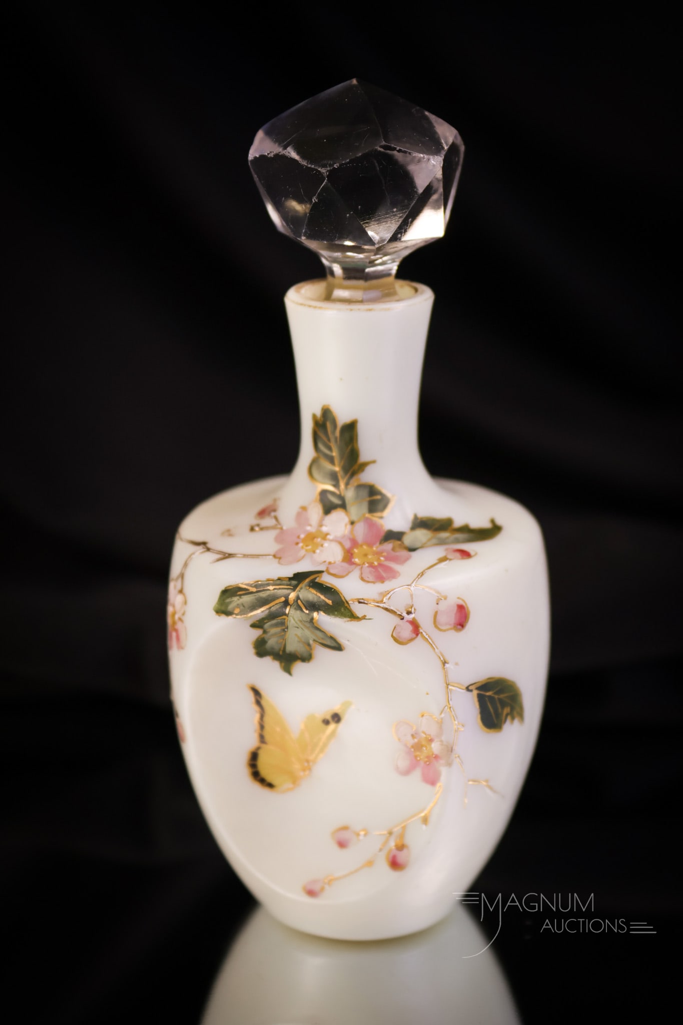 Uranium Enamel Gilt Decorated Uranium Glass Diminutive Perfume Bottle: A finely decorated enamel and gilt decorated uranium-rich glass perfume bottle. This piece features a decoration of flowers and foliage and a butterfly. The perfume has pinched sides. It measures 4 1/