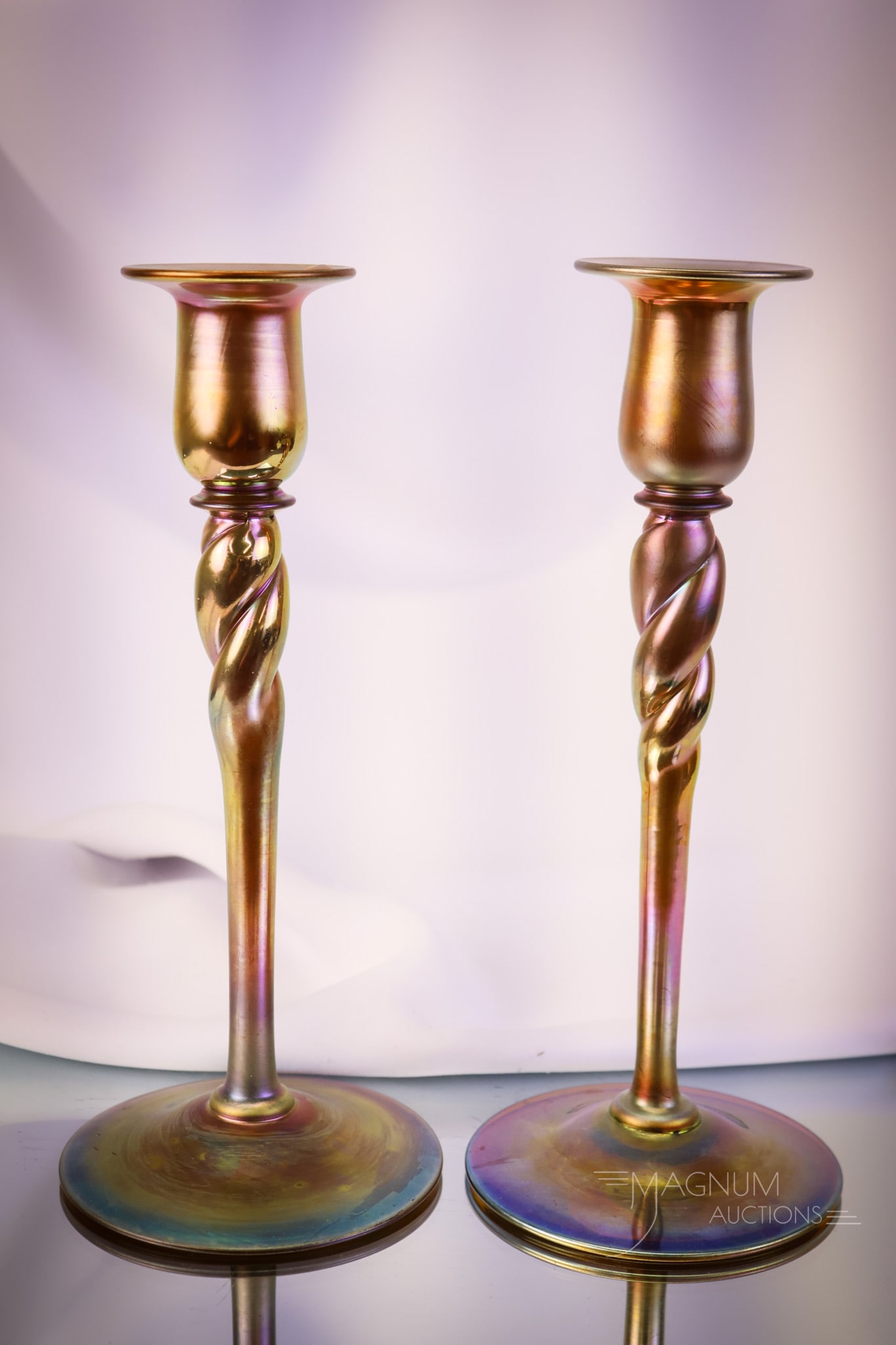 Pair of Steuben Glass Gold Aurene Twist 10 1/4" Candlesticks: A select offering of a pair of signed "Aurene" Steuben candlesticks. Each measures 10 1/4" tall and features the classic twist form. A lovely find for your collection SHIPPING NOTICE: If you choose no