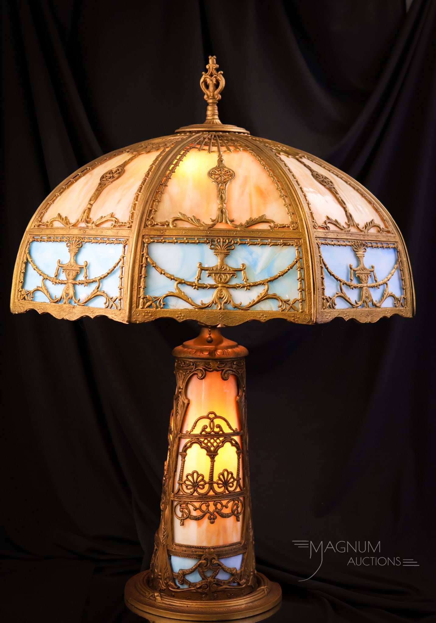 Antique Empire 22 Panel Slag Glass Table Lamp: A gorgeous Empire antique table lamp. This lamp has blue and caramel slag glass panels throughout. There are 22 in all. The base is let and has curved panels as well. The lamp measures 28" tall and 20