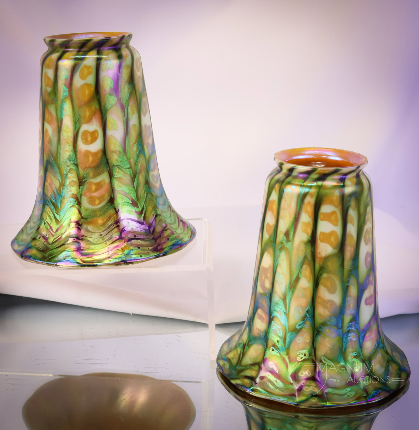 Pair of Quezal Snakeskin Electric Iridescent Art Glass Shades: A wonderful pair of signed Quezal art glass shades. Each has a snakeskin pattern with an electric iridescence of greens and blues. Each shade measures 5" tall and 4 3/4" wide. SHIPPING NOTICE: If you 