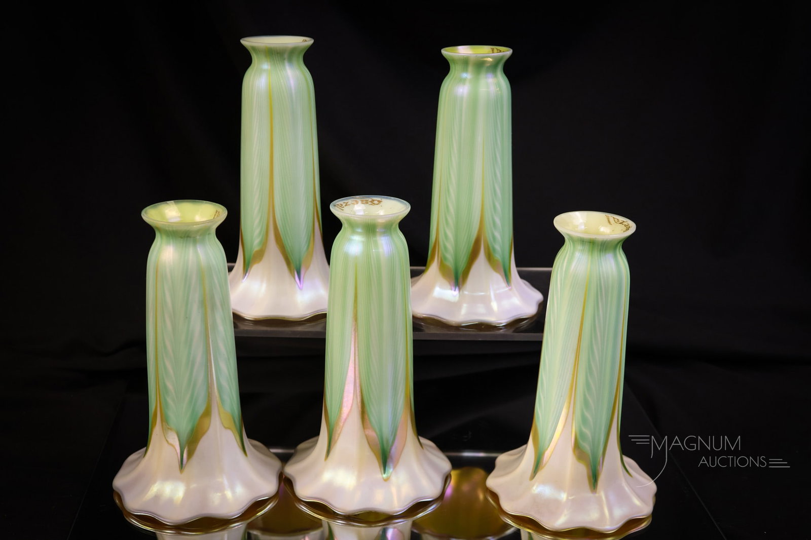 Set of 5 Signed Quezal Pulled Feather Iridescent Art Glass Shades: A select offering of a set of five signed Quezal pulled feather art glass lily shades. Each shade has a green and gold iridescent pulled feather design on a white background and an orange iridescent