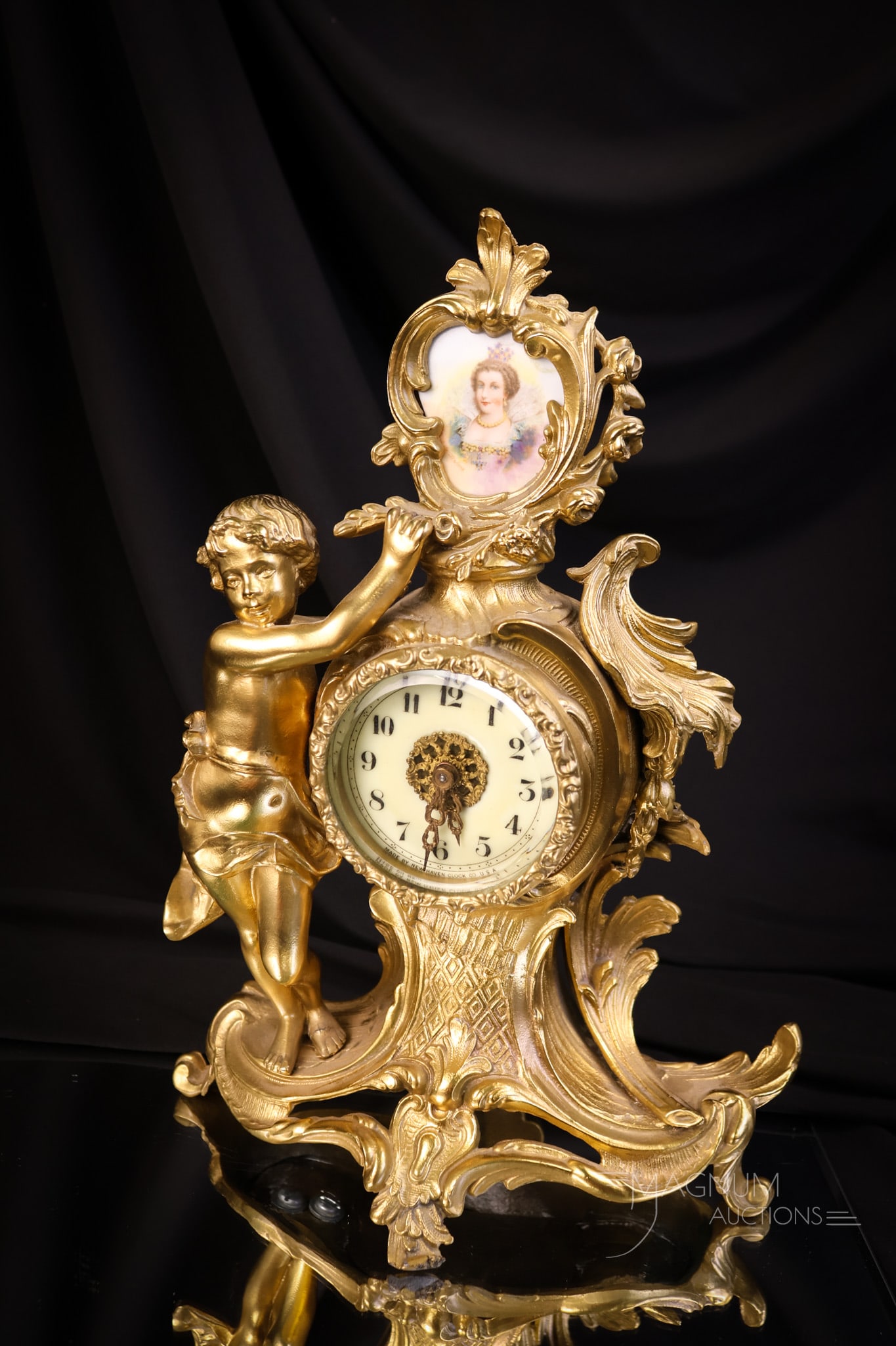 New Haven Gilt Putti Porcelain Portrait Plaque Figural Clock: A beautiful gilt New Haven Victorian figural putti mantle clock. This clock features a gilt case and a porcelain portrait plaque at the top. The clock measures 12" tall and 9" wide. The clock is untes
