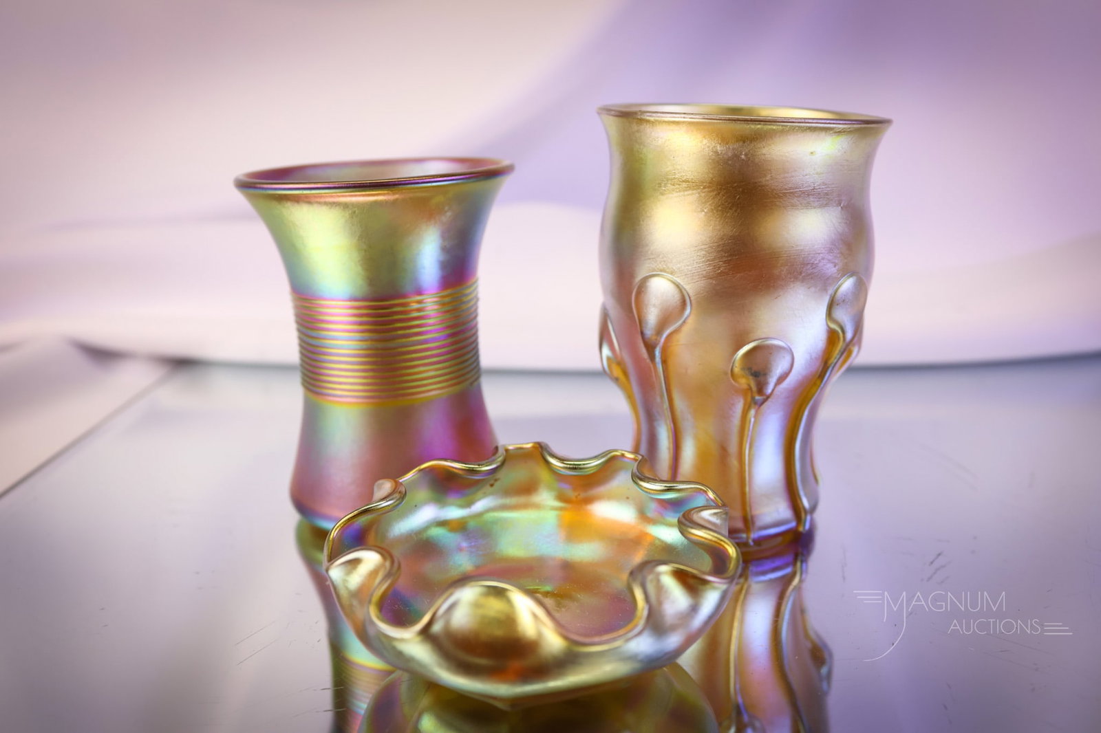 3 pc Lot Gold Iridescent Art Glass Miniatures Tiffany & Quezal: Three delights in gold iridescent art glass miniatures. The first is a signed, "L.C.T." Tiffany ruffled open salt. The second is a signed, "L.C.T. N8224" Tiffany tadpole whisky. The third is a signed 