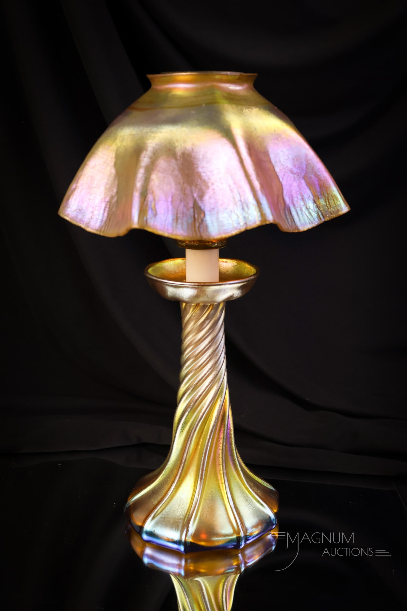 Signed "L.C.T." Tiffany Favrile Iridescent Glass Candle Lamp: A beautiful signed, "L.C.T." Tiffany Favrile glass candle lamp. This superbly colored piece has electrifying iridescence. The shade has an onion-skin finish. Both shade and base are signed. The lamp m
