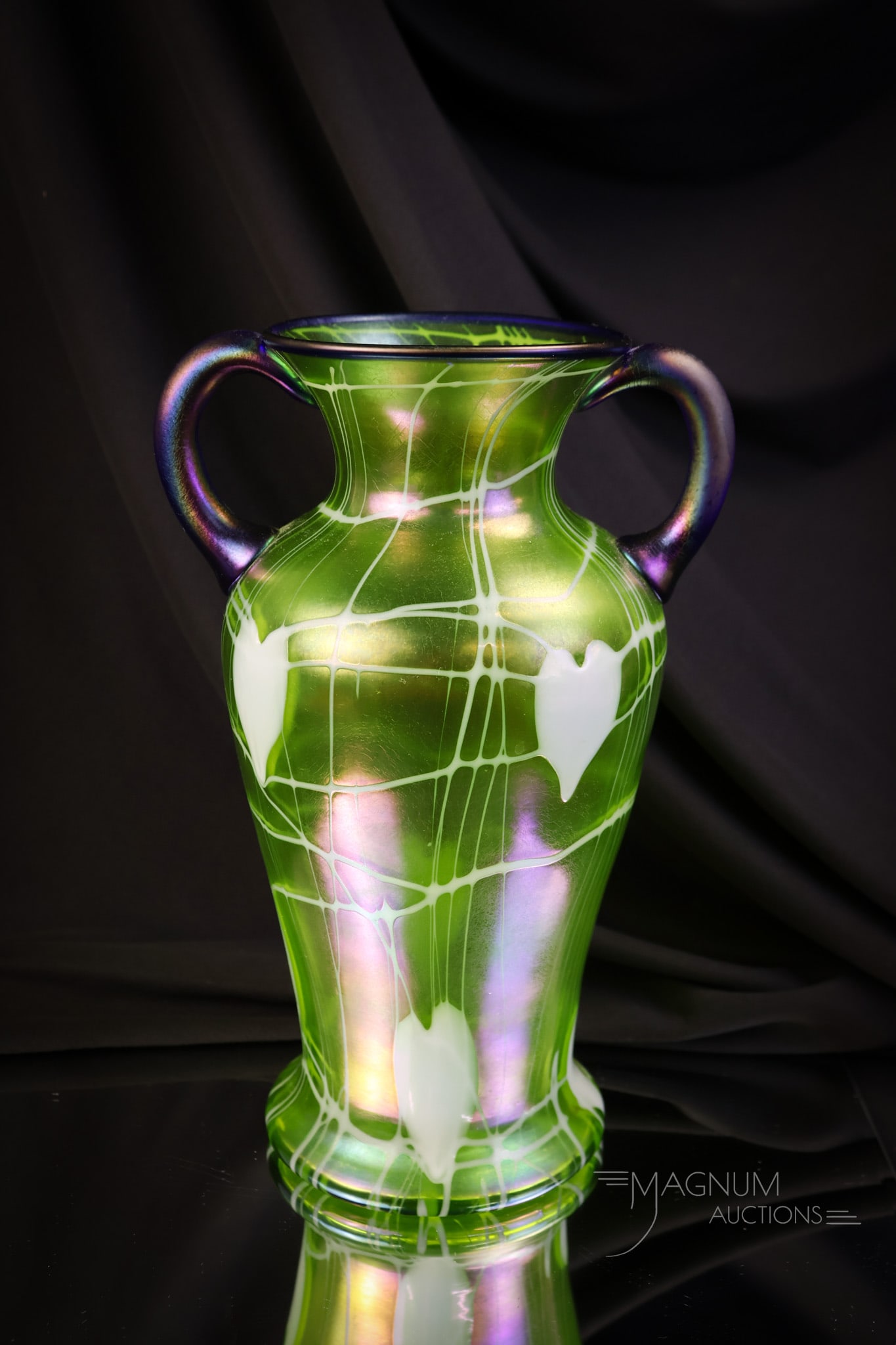Imperial Freehand Olive Green Cobalt Handled Heart & Vine 10" Vase: A perfect addition to any Imperial art glass collection. This piece is in olive green with heart and vine decoration and cobalt handles and rim. The vase has white hearts and vines around the body. Th