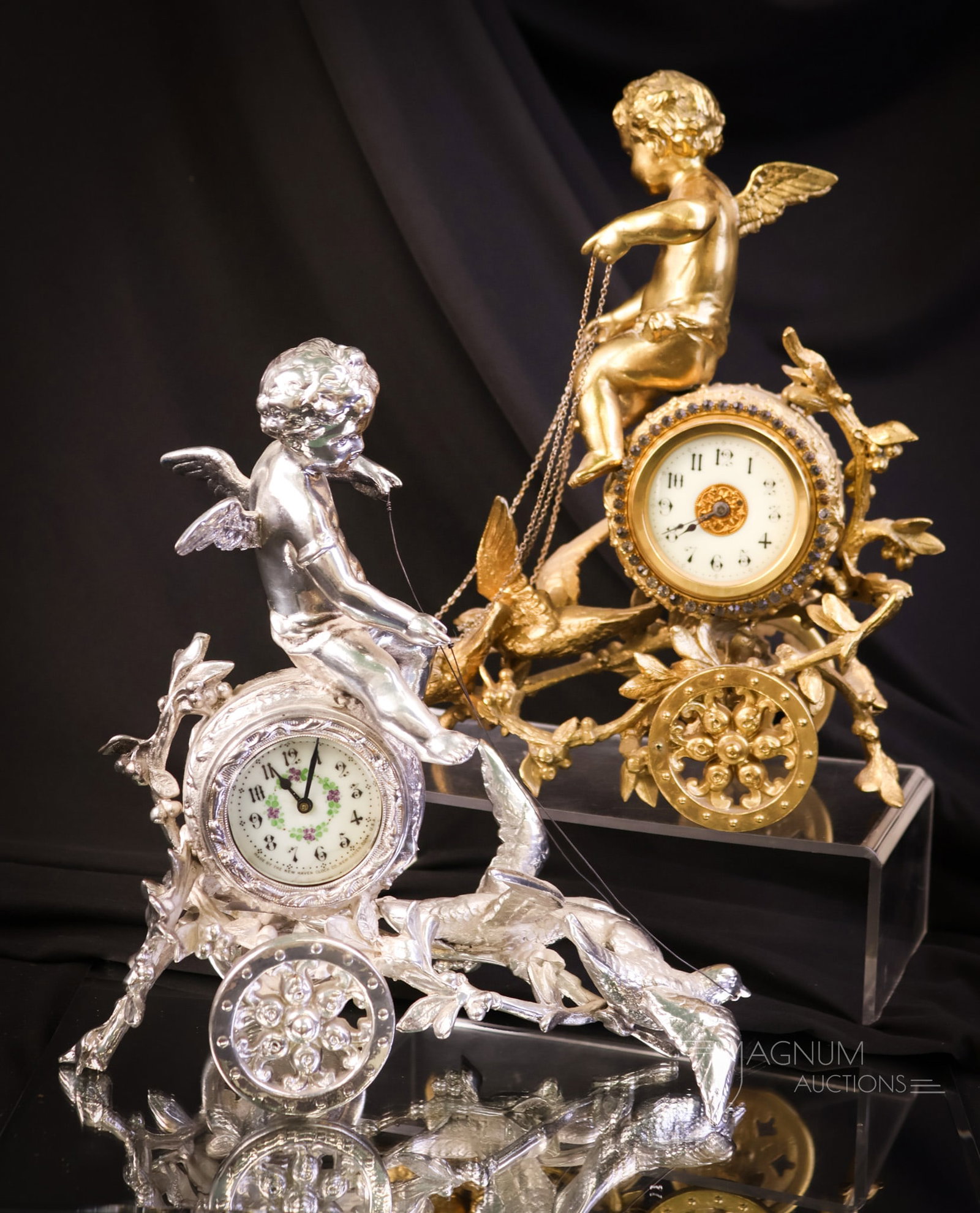 2 pc Lot Figural Victorian Cherub & Doves Clocks Silver & Gold New Haven & More: Two identical finds in Victorian figural clocks. One clock has a silverplated case. The other is gold-plated. Both feature a cherub in a chariot and doves at the reins. The silver example has a "New H