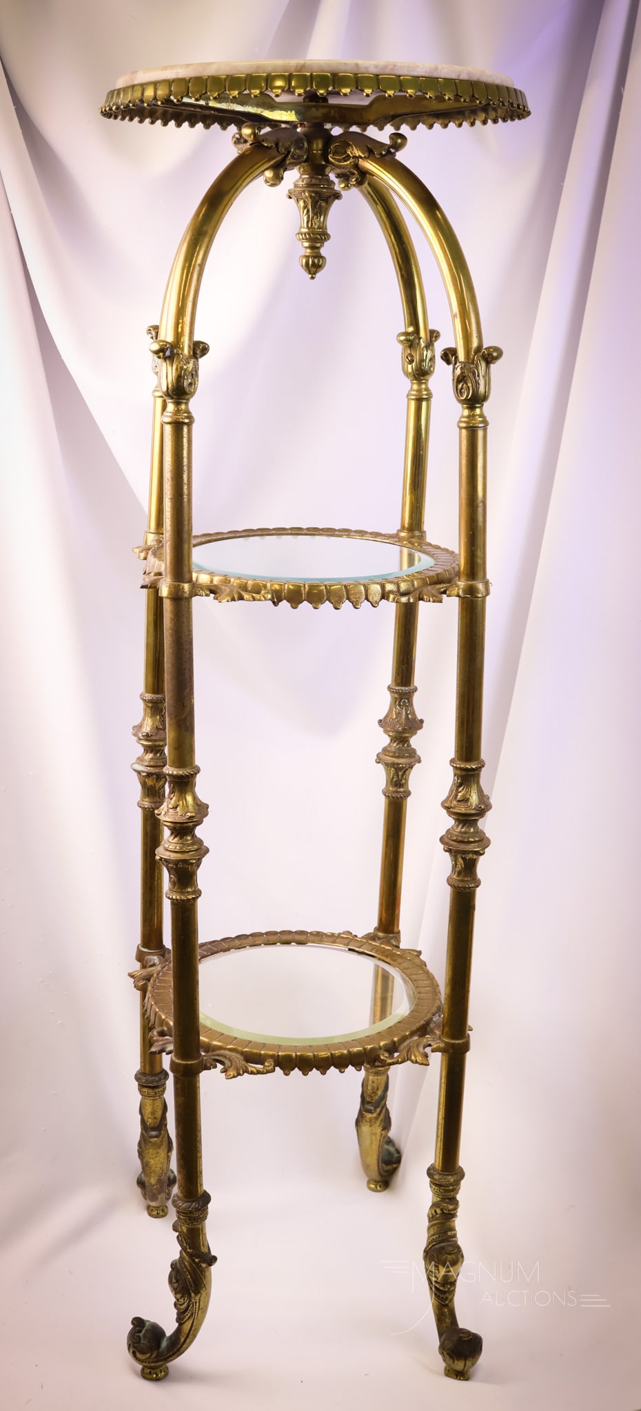 Hollywood Regency Brass Marble Beveled Glass Pedestal Stand: A gorgeous Hollywood Regency period brass and glass pedestal stand with a marble top. This piece is quite decorated and will fit in those homes that are full to the gills. This stand features an ornat