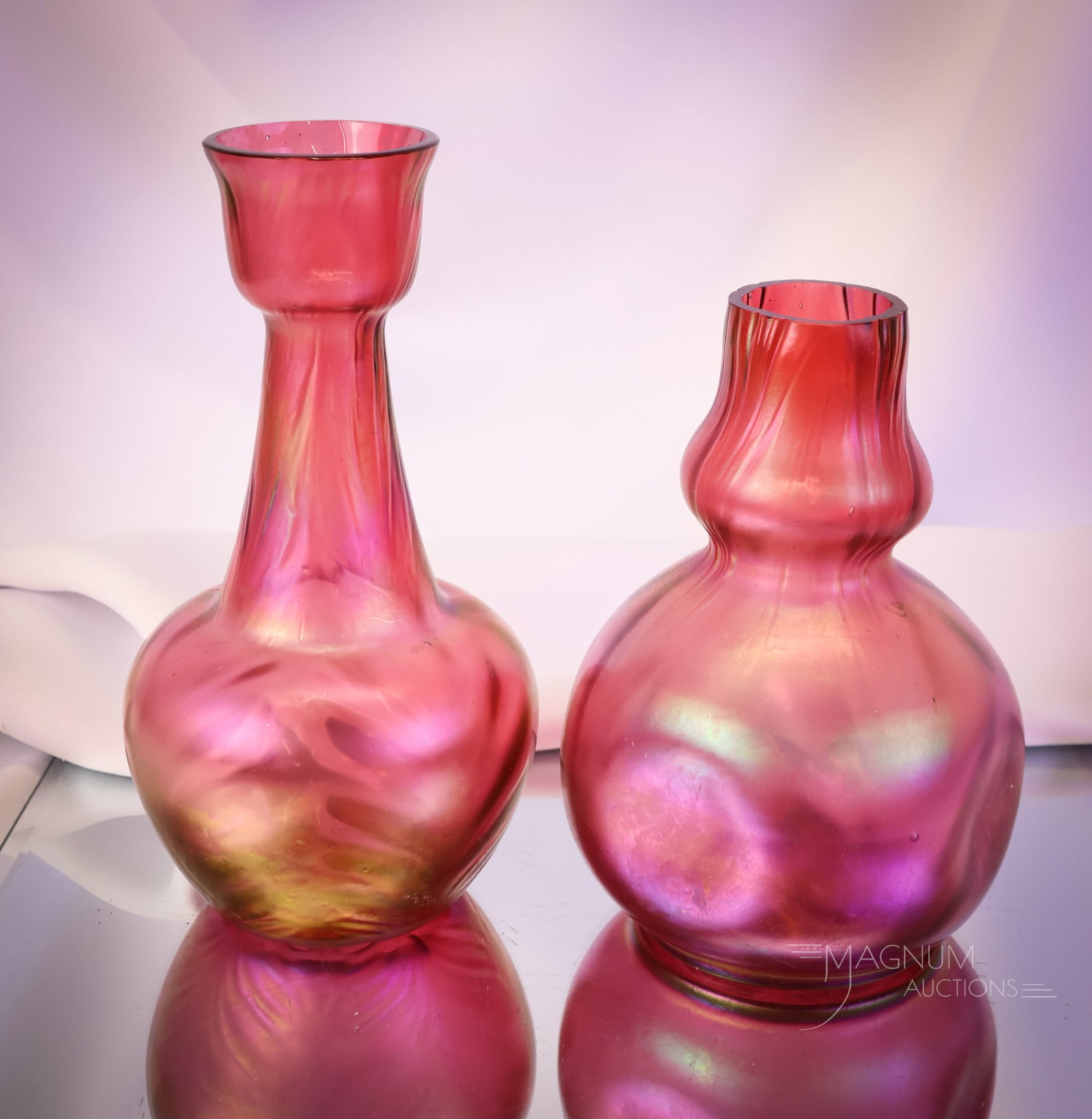 2 pc Lot Kralik Red Iridescent Art Glass Vases: Two desirable finds in red iridescent Kralik art glass vases. The tallest measures 8 1/4" tall. SHIPPING NOTICE: If you choose not to utilize the LiveAuctioneers LiveShip program, MAGNUM AUCTIONS alwa