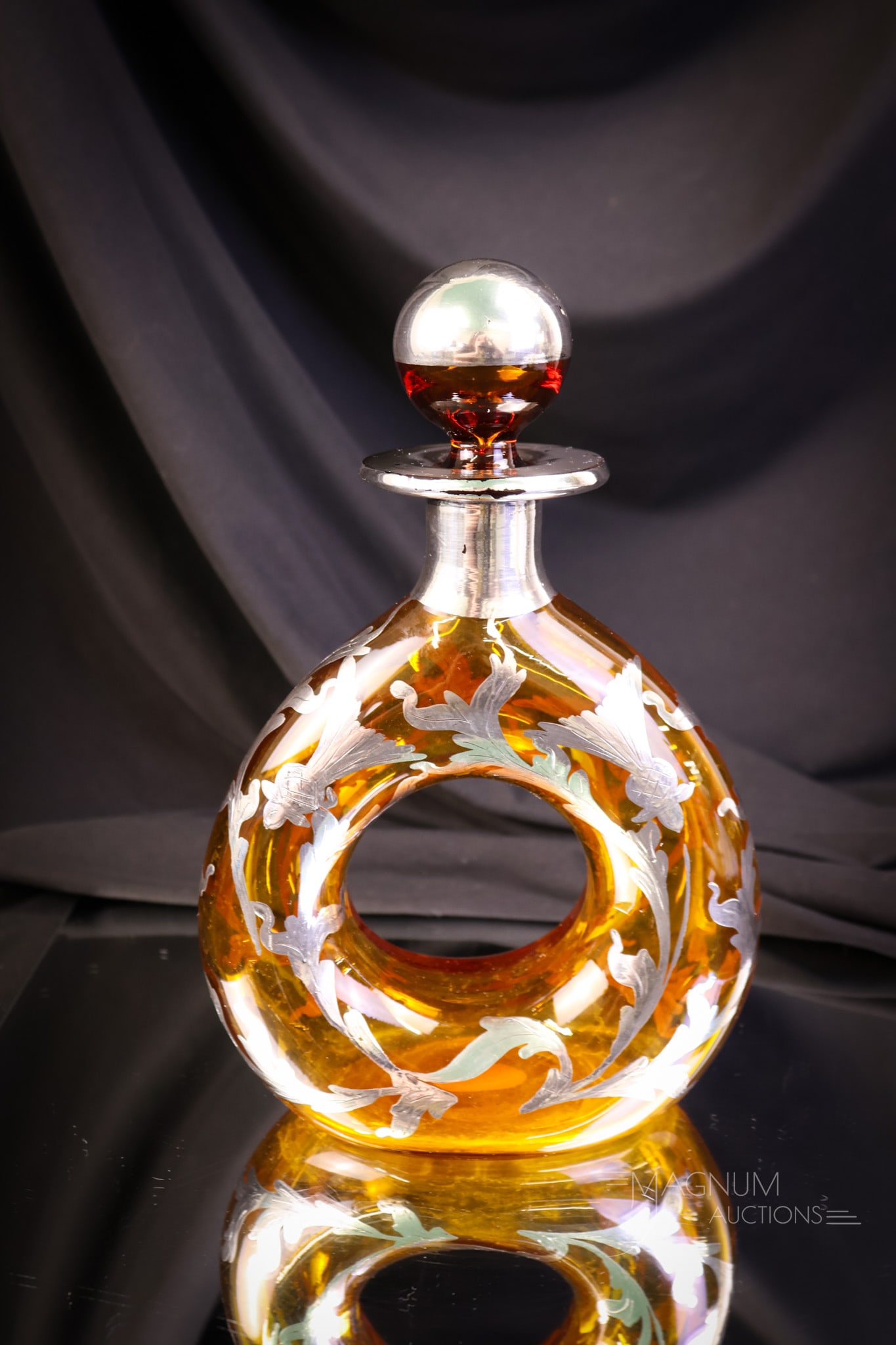 Sterling Silver Overlay Amber Art Glass Donut Decanter: A beautiful find in amber art glass and sterling silver. This is a donut decanter with rich sterling overlay in a thistle pattern. The decanter measures 9" tall and 6" wide. SHIPPING NOTICE: If you ch