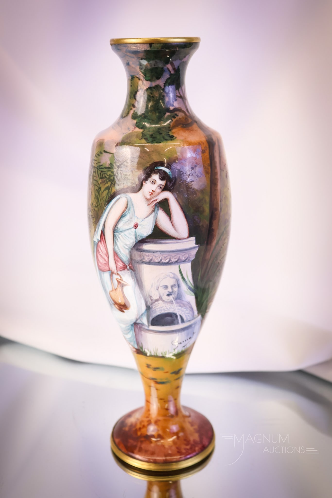 French Enamel on Copper 10" Woman At Fountain Antique Vase: A fine find in French enamel on copper. This vase is larger than most at 10" tall. It features a woman at a figural fountain and a lake scene. The piece is artist-signed. The vase measures 10" tall an