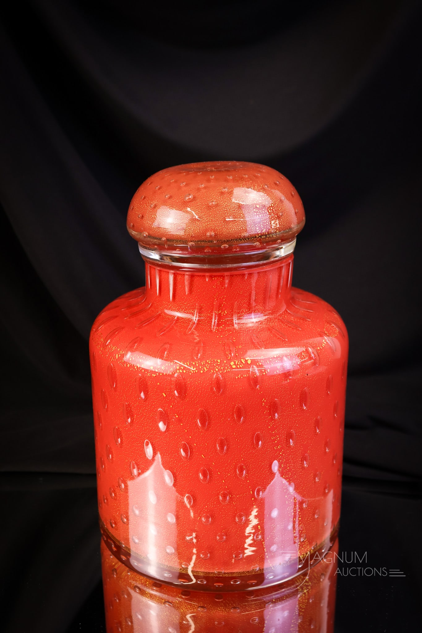 Italian Murano Aventurine Art Glass MCM Covered Jar: A vintage MCM Red-Orange Italian Murano art glass air trap mother-of-pearl with aventurine art glass covered jar. This piece is wonderful with its gold flecks. This piece measures 9" tall and 5 1/4" w