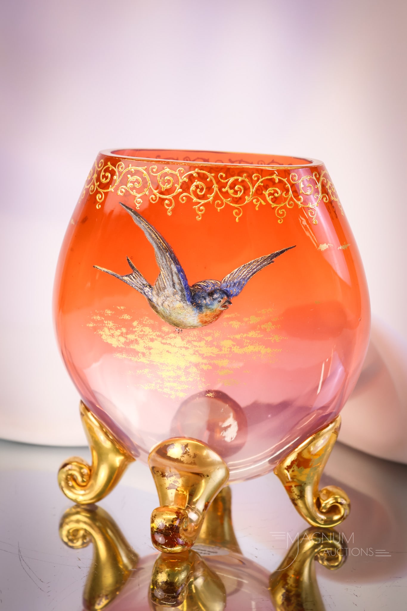 Moser Orange Glass Gilt Enameled Blue Bird Pillow 6" Vase: A scarce find in decorated Moser glass. This is a pillow vase in orange glass. The vase has applied glass feet and has the welcome addition of a heavy, built-up decoration of a bluebird. This fine exa