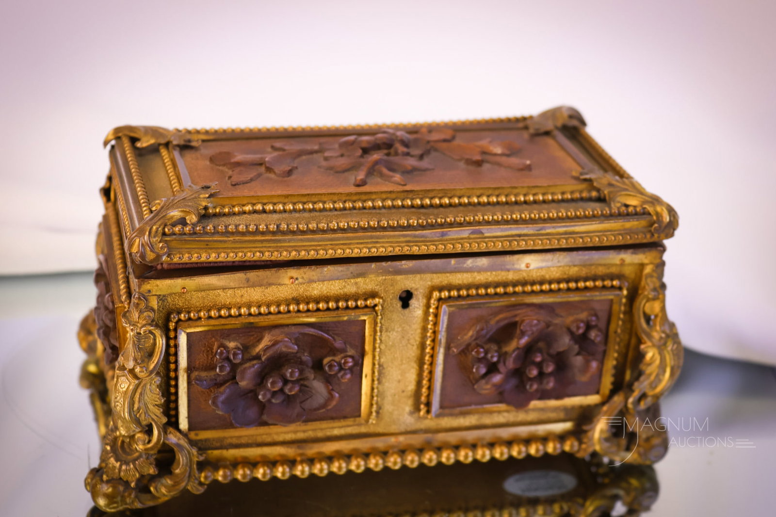 French Napoleon III Gilt Bronze & Carved Wood Antique Casket: A beautiful and unusual find. This is a French Napoleon III gilt bronze casket. This casket has added decoration of carved wood panels around the body. The casket measures 3 3/4" tall and 7" wide. The