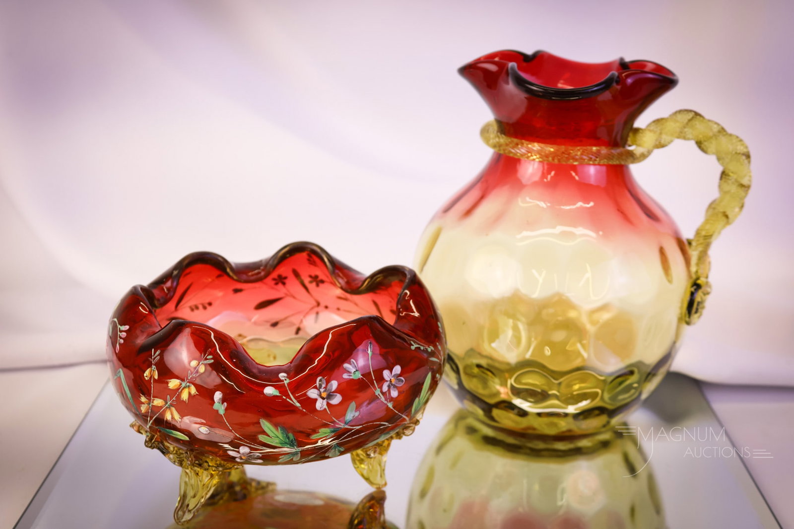 2 pc Lot Victorian Amberina Victorian Glass Rope Handle Pitcher & Rose Bowl: Two fine and desirable finds in Victorian amberina glass. The first is a rope handle water pitcher with a twisted amber handle. The second is a rose bowl with three applied feet and floral enameling. 