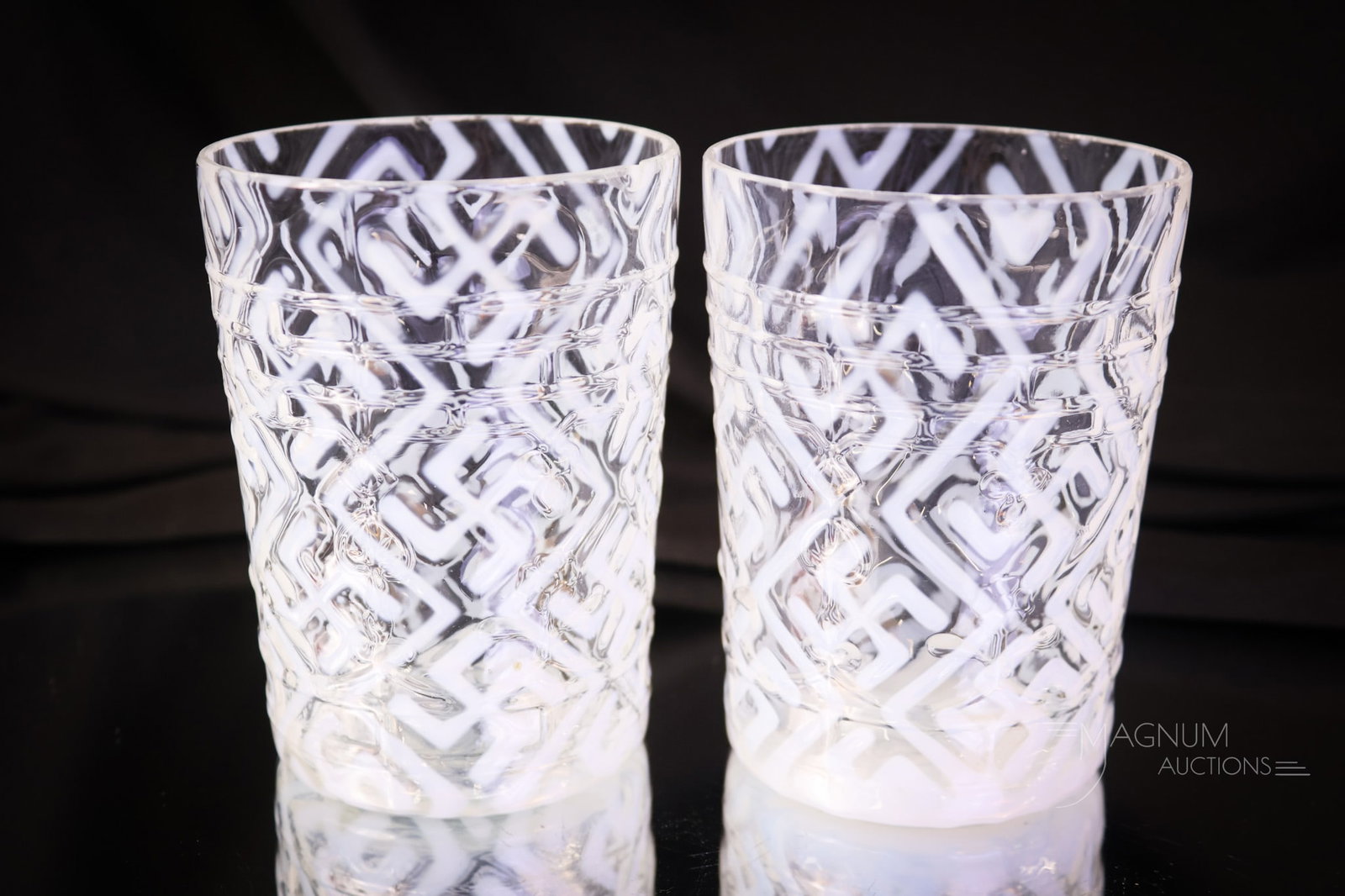 2 pc Lot Opalescent Victorian Northwood Swastika Tumblers: two seldom seen tumblers that are very elusive. Both are in the Spades and Clubs mold. The opal pattern is Swastika. The height is 3 7/8". One tumbler exhibits minor rim flakes, and the other has a ri