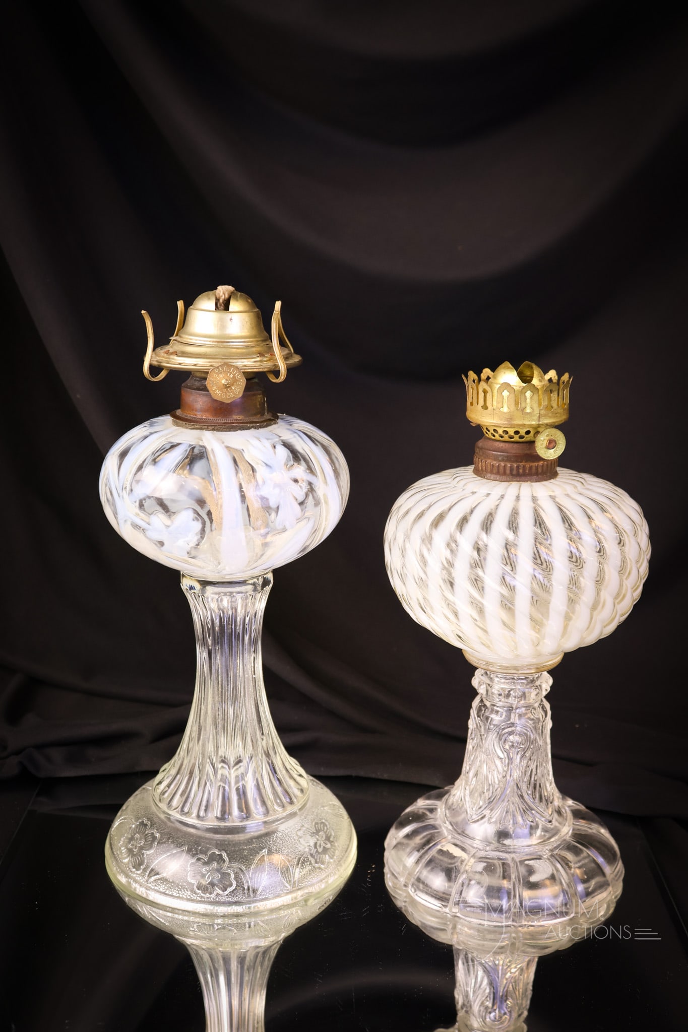 2 pc Lot Victorian Opalescent Vaseline & More Oil Lamps: Two nice finds in Victorian oil lamps. The first is a light vaseline Reverse Swirl pattern. The second is a crystal opalescent Daffodils pattern example. The tallest measures 8" to the burner collar. 