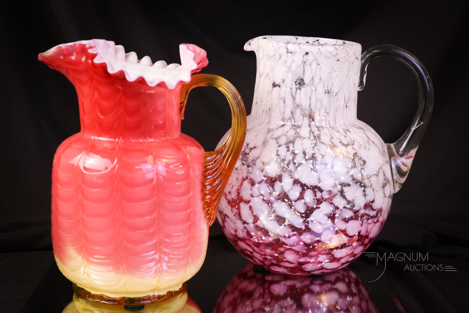 2 pc Lot Victorian Phoenix Harrach Art Glass Water Pitchers: Two fine examples of Victorian art-glass water pitchers, attributed to Phoenix or Harrach. The first is a ruby-to-clear with white spatter and aventurine mica inclusions. The second is a peachblow wit