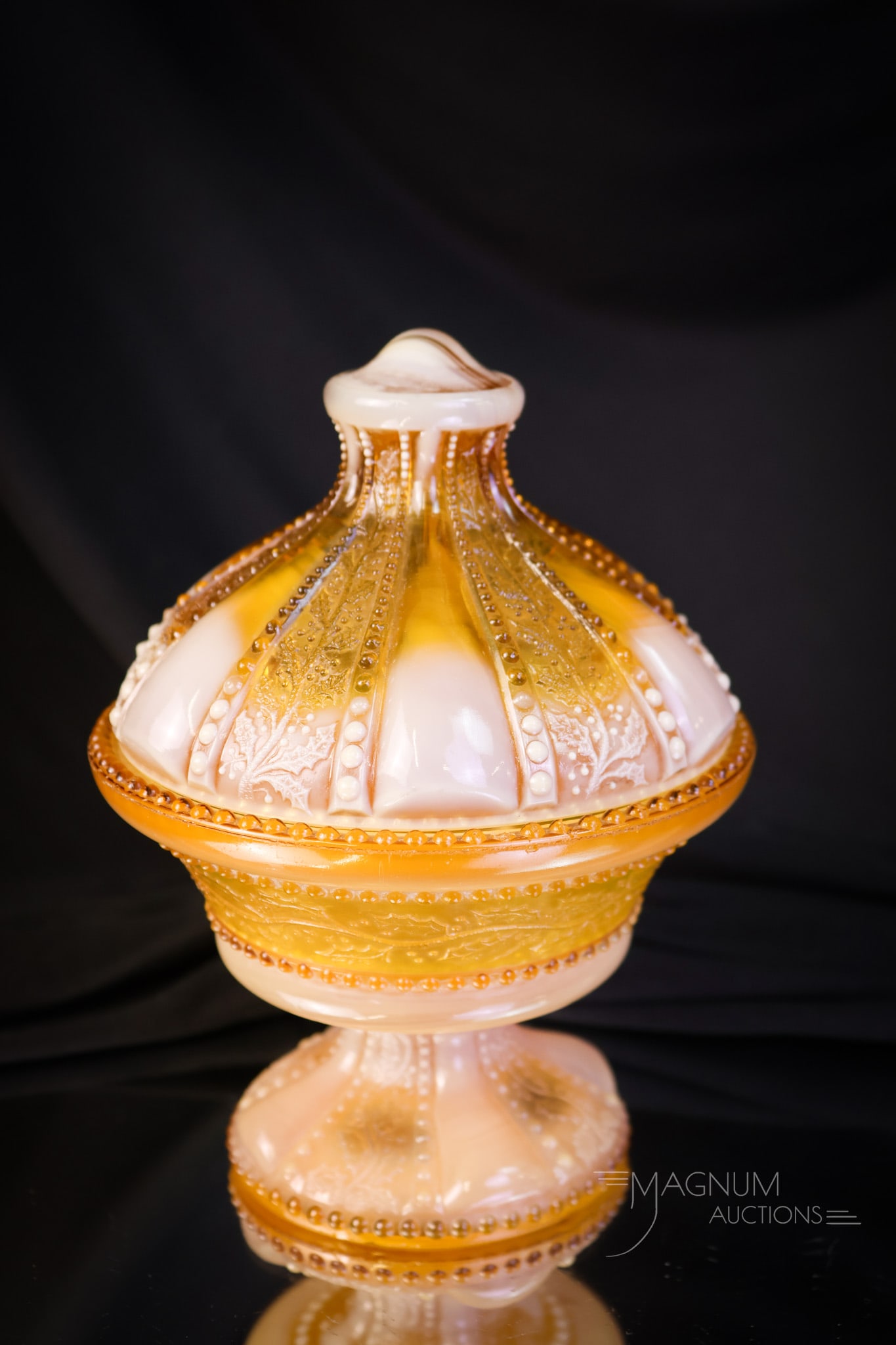 Greentown Victorian Holly Amber Covered Compote: An elegant find in Victorian Greentown Holly Amber glass. This piece is a covered compote. This small covered compote measures 5 1/.2" tall and 4 3/4" wide. The piece exhibits a chip to the flange of 