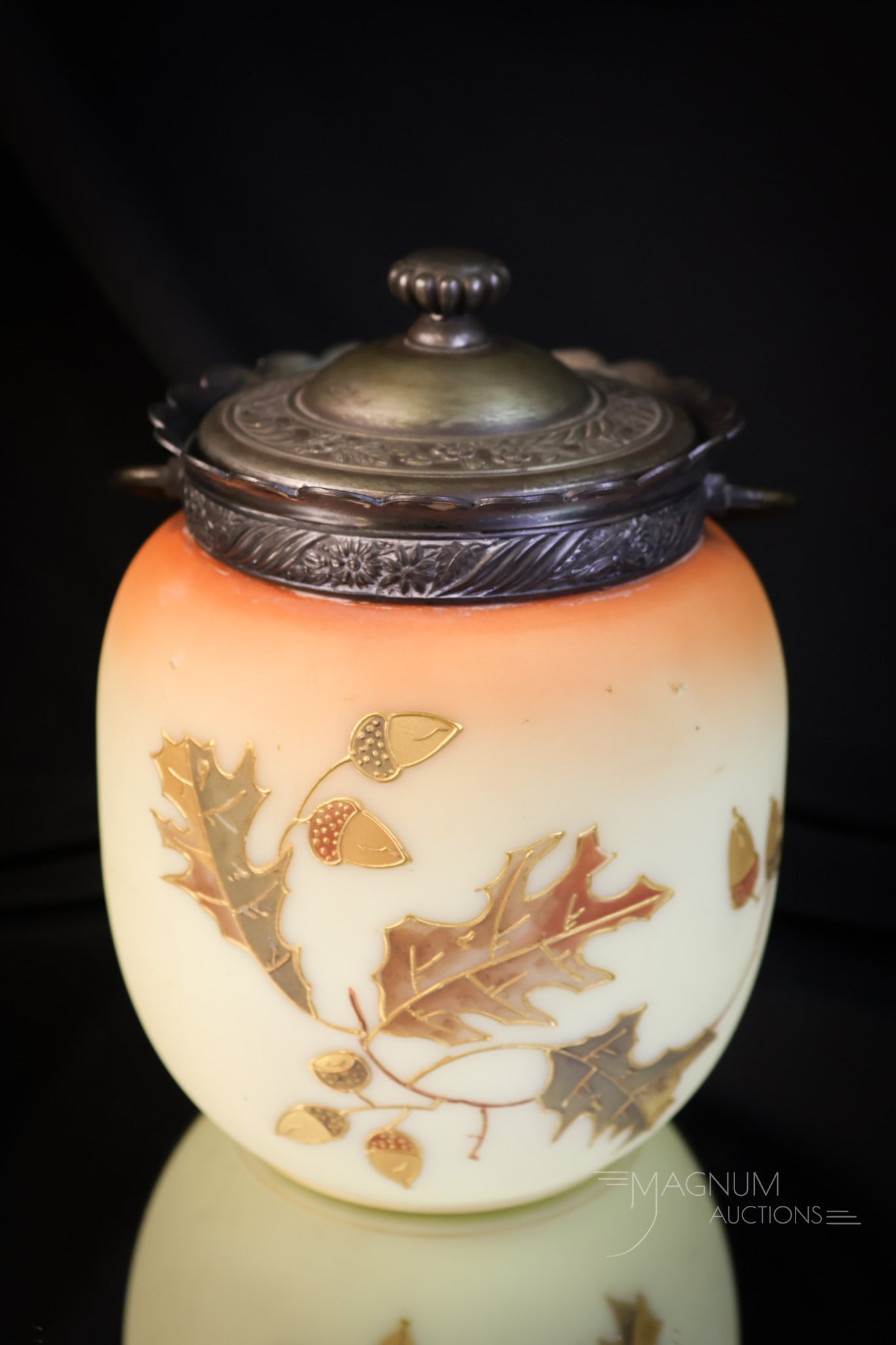 Mt. Washington Victorian Crown Milano Glass Biscuit Jar: A beautiful find in a Mt. Washington Victorian glass biscuit jar. This particular piece features a decoration of oak leaves and acorns on a burmese colored ground. The piece measures 7" tall and 5" wi