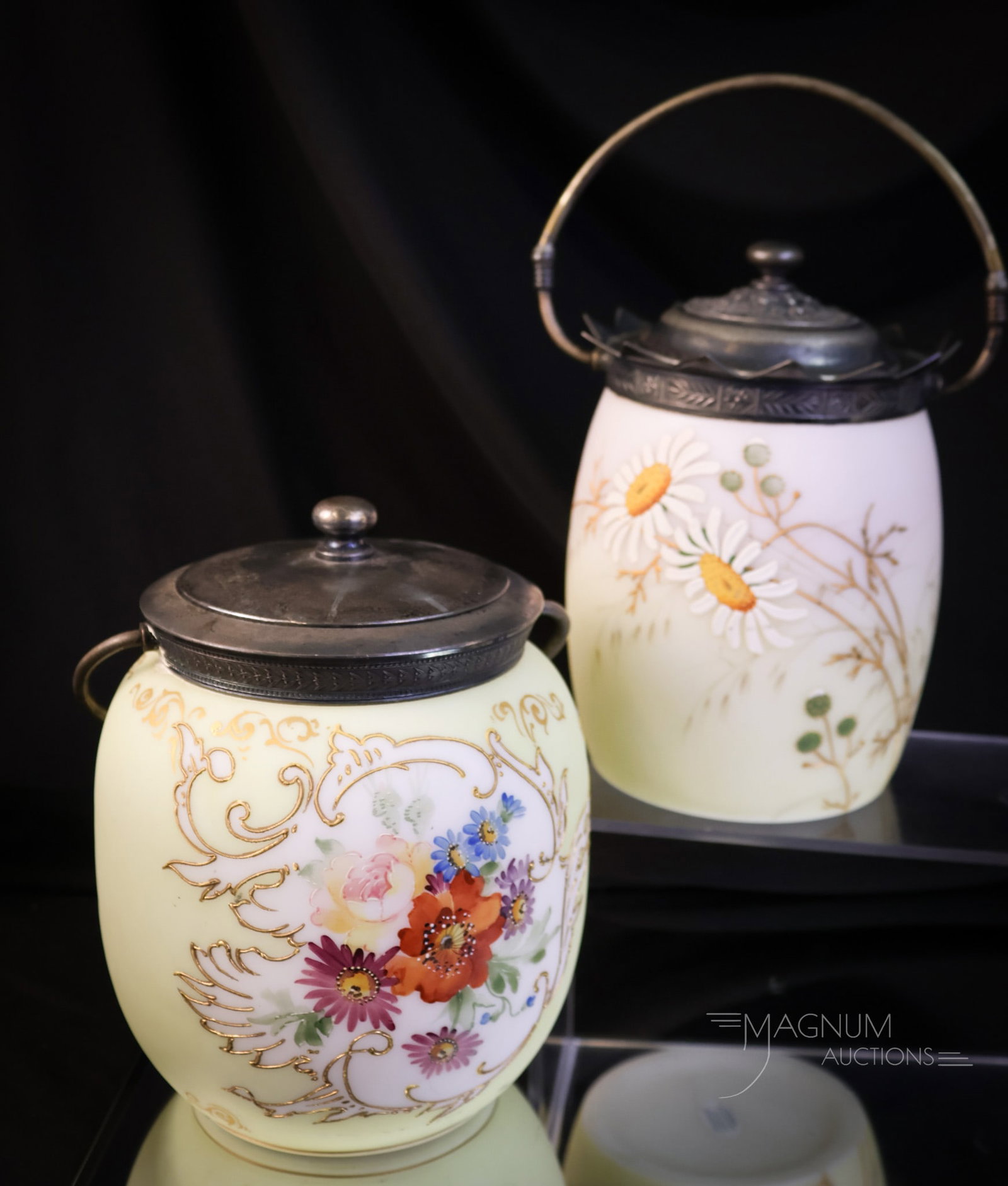 2 pc Lot Victorian Glass Biscuit Jars Mt. Washington Glass & More: Two beautiful biscuit jars from the Victorian era. The first is a Mt. Washington floral decorated example with gold scrolling. The lid is marked "M.W." The second is a floral enameled example attribut