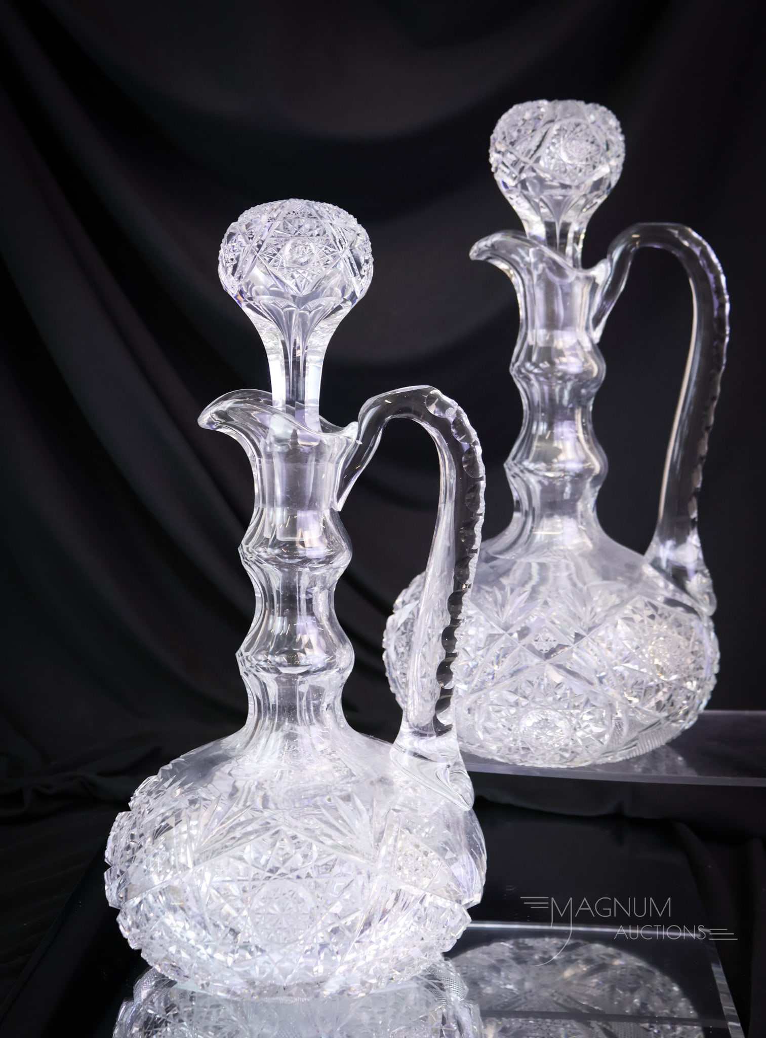 Pair of ABP American Brilliant Period Cut Glass Decanters: A wonderful pair of American Brilliant Period cut glass decanters. Each has notched handles and cut with a Hobstar & Fan pattern. The decanters have matching stoppers. Each measures 13" tall and 6" wi