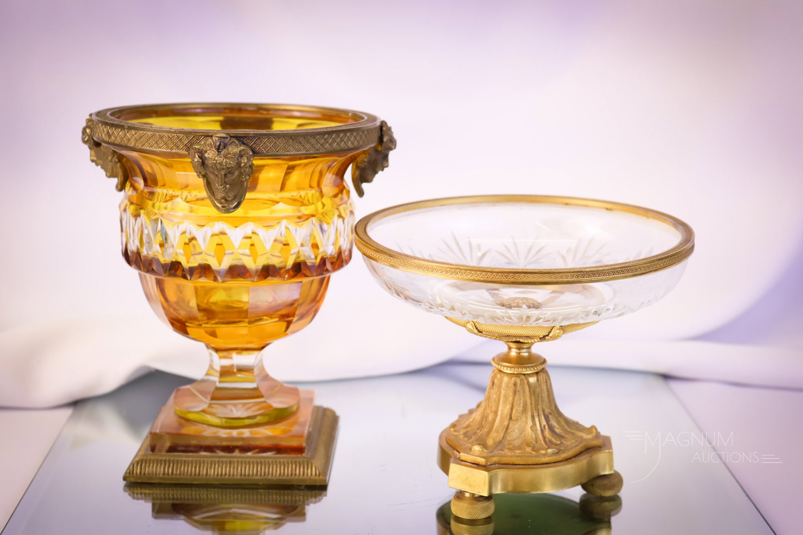 2 pc Lot Empire Bronze Mounted Crystal Compotes: Two beautiful finds in Empire cut crystal bronze-mounted compotes. The first is a cut clear crystal example. The second is an amber-stained urn form with figural mountings in bronze. The tallest measu
