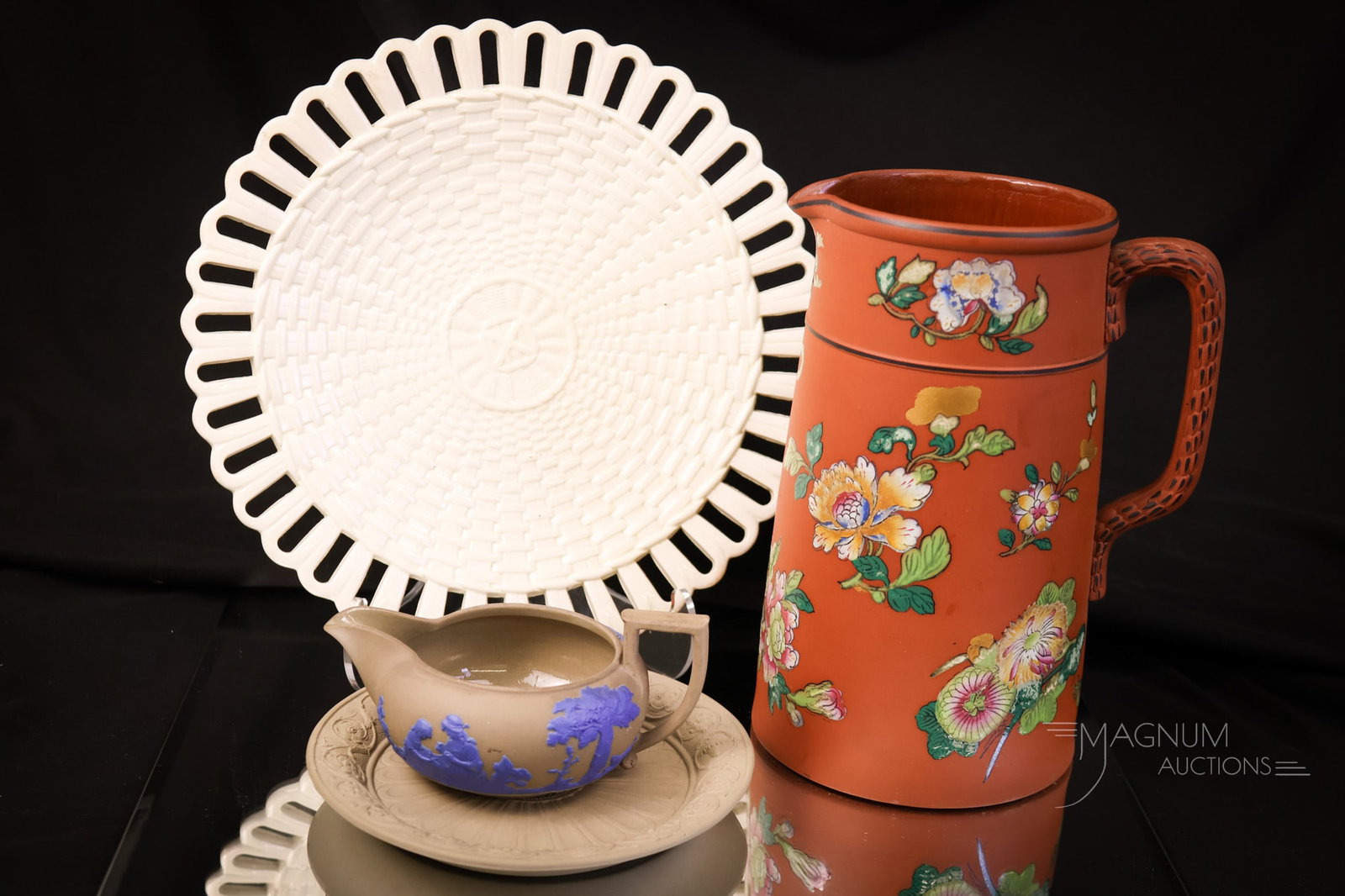 4 pc Lot Wedgwood: Four selections in Wedgwood that are sure to please. The first is a Terra Cotta Antico Rosso enameled flowers pitcher. The second is an ivory trivet. The third is a creamware open-edge lace plate. The