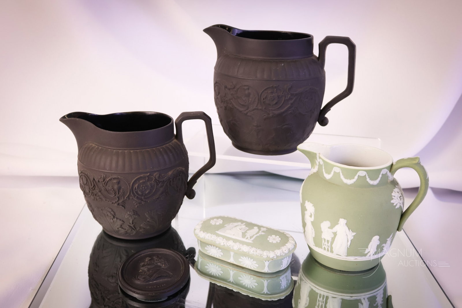 5 pc Lot Marked Wedgwood Basalt & More: Five desirable finds in marked Wedgwood. There are three pieces of black basalt, including two pitchers and a small Voltaire plaque. The fourth is a green Jasperware oval box. The final piece is a sma