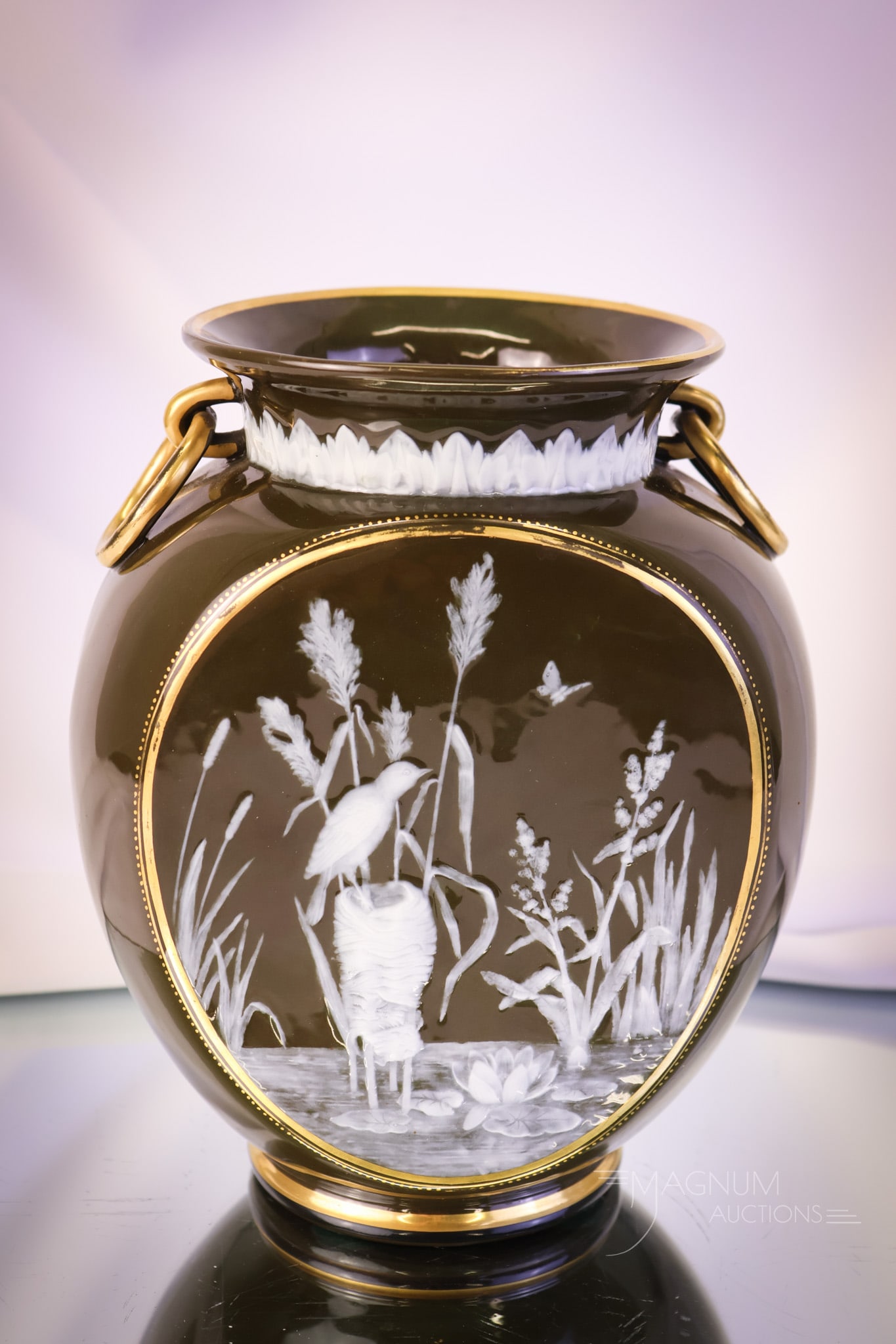 George Jones Pat-Sur-Pate Vase: A gorgeous George Jones Pat-Sur-Pate vase. This ovoid-form vase features ring handles and is in olive green with gilt trim. The vase is decorated with a marsh and bird scene. The vase measures 8 1/2" 