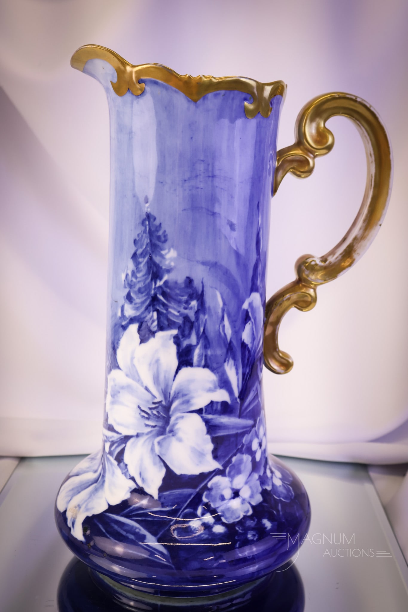 Vienna Austria Flow Blue Lilies 14" Tankard Pitcher: A wonderful find in a Vienna Austrai Flow Blue tankard pitcher. This pitcher measures 14" tall and 8 1/4" wide. It is hand-painted with lily flowers and embellished with gold. SHIPPING NOTICE: If you 