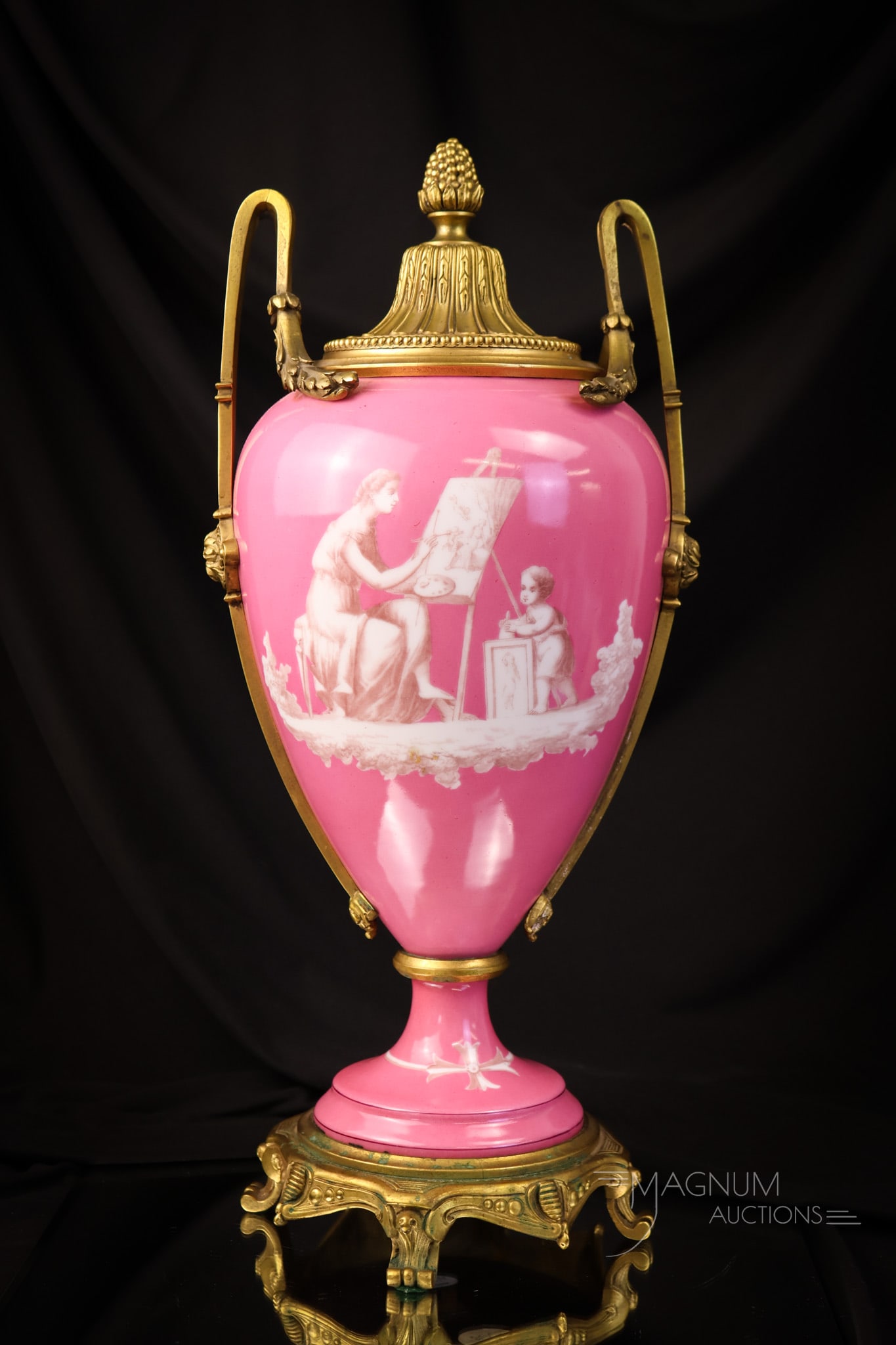 17" Sevres Style Gilt Bronze Enameled Urn: A super and very impressive find in a Sevres style porcelain urn with gilt bronze fitting and lid. It is is a gorgeous shade of pink with enameled decoration of a painter and a child. The Urn measures