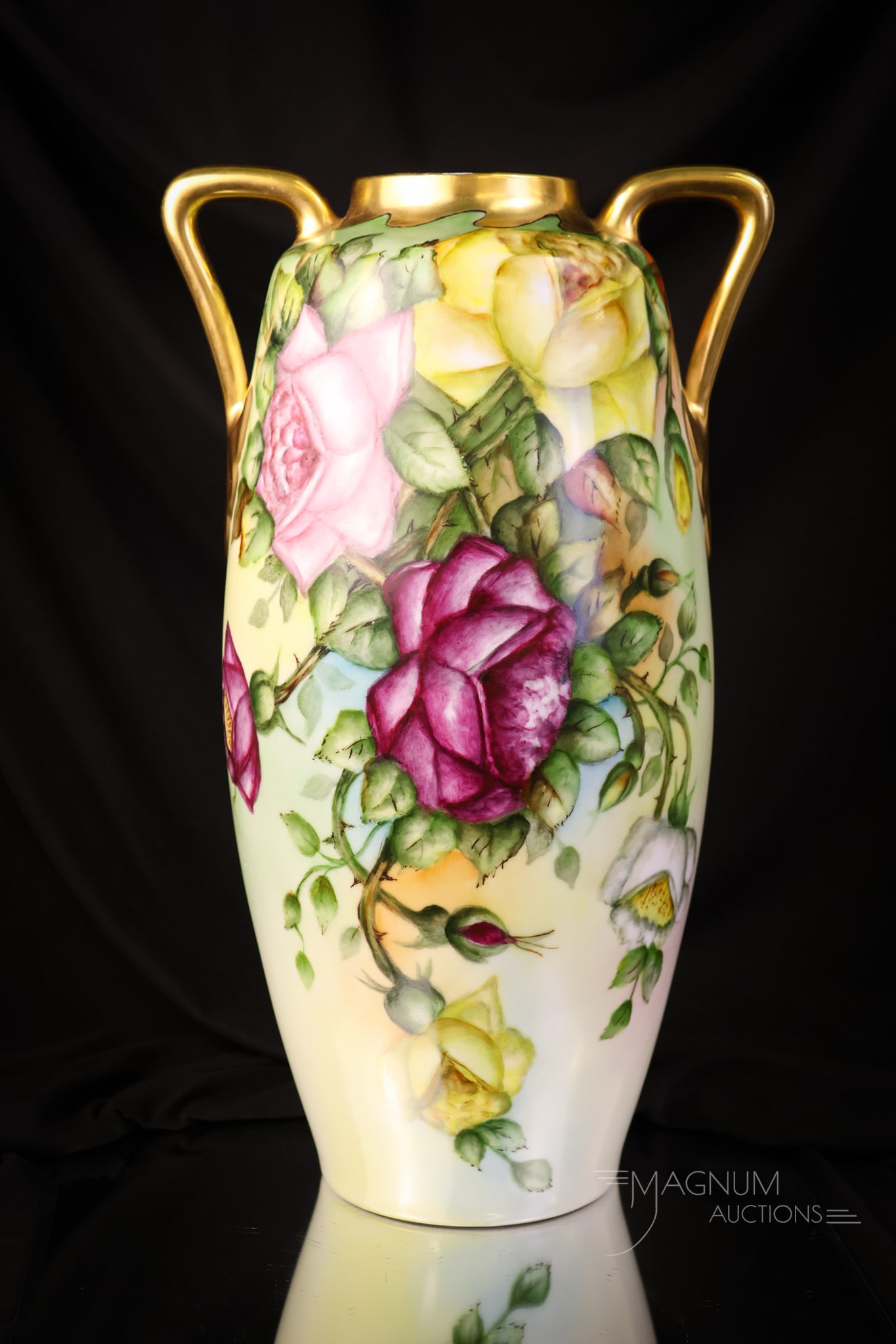 15 1/2" Roses Hand Painted Porcelain Double Handle Vase: An impressive find in a hand-painted porcelain 15 1/2" tall vase. This vase is 9" wide as well. It is decorated with yellow, pink, and red roses on one side and pink roses on the reverse. The vase has