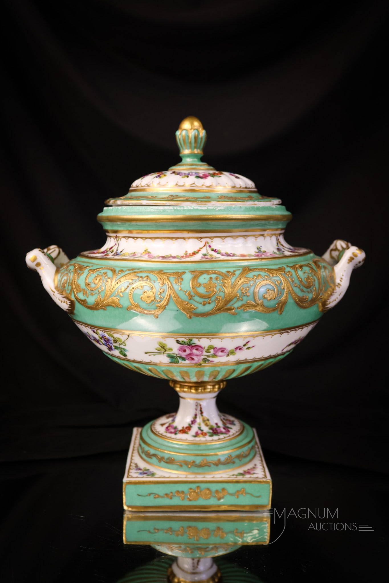 339 Sevres Porcelain Pedestal Covered Urn: A wonderful find in a Sevres pedestal covered urn. This piece is in a mint green coloring with overall floral decoration, gold scrolling, and trim. The urn is in two pieces and is bolted. The urn meas